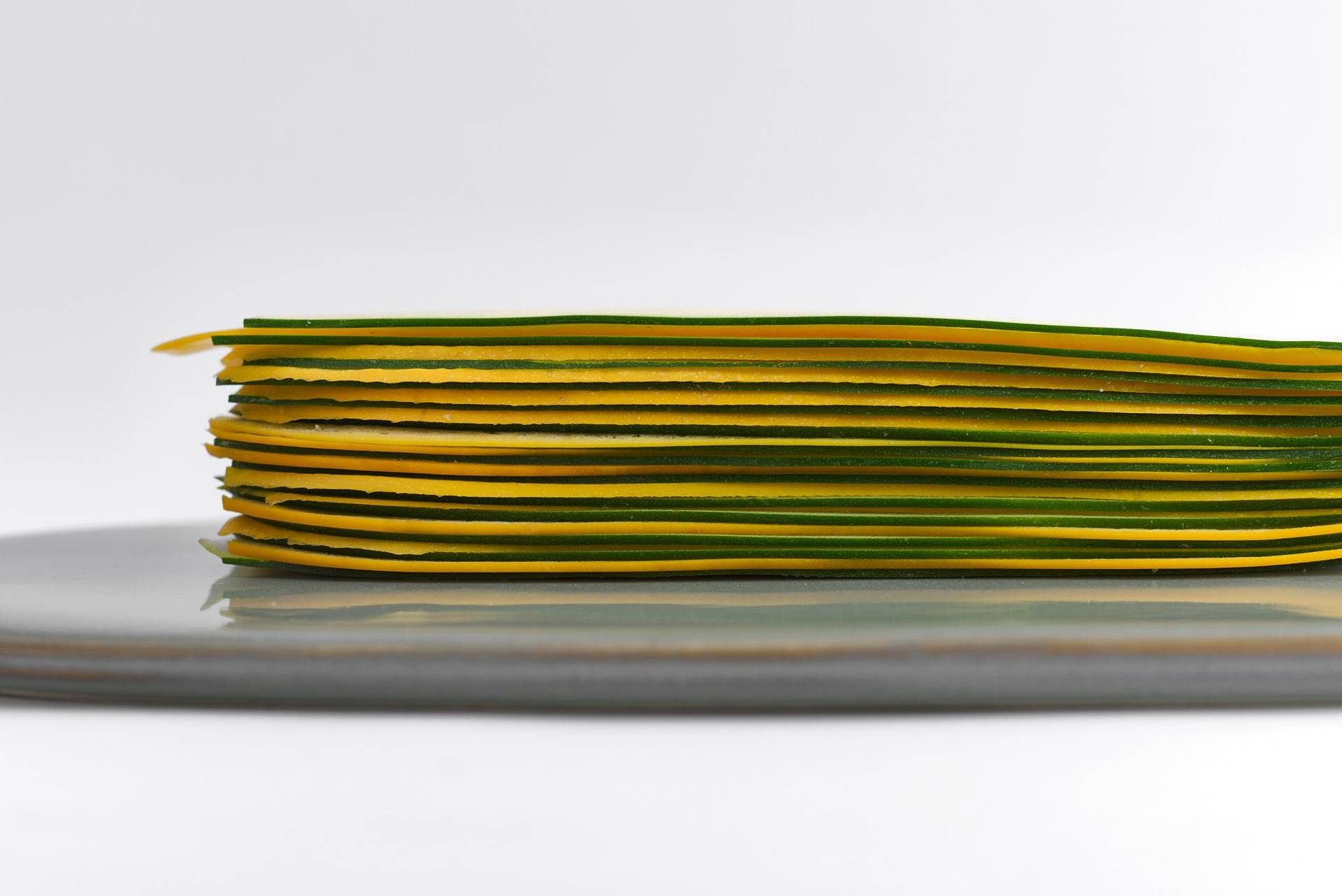 sliced courgette mille feuille on a gray plate with white background