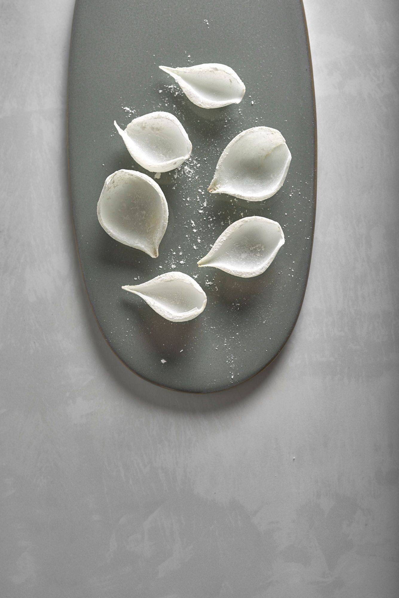 mehlierte zwiebeln auf einem grauen teller mit weißem steintisch
