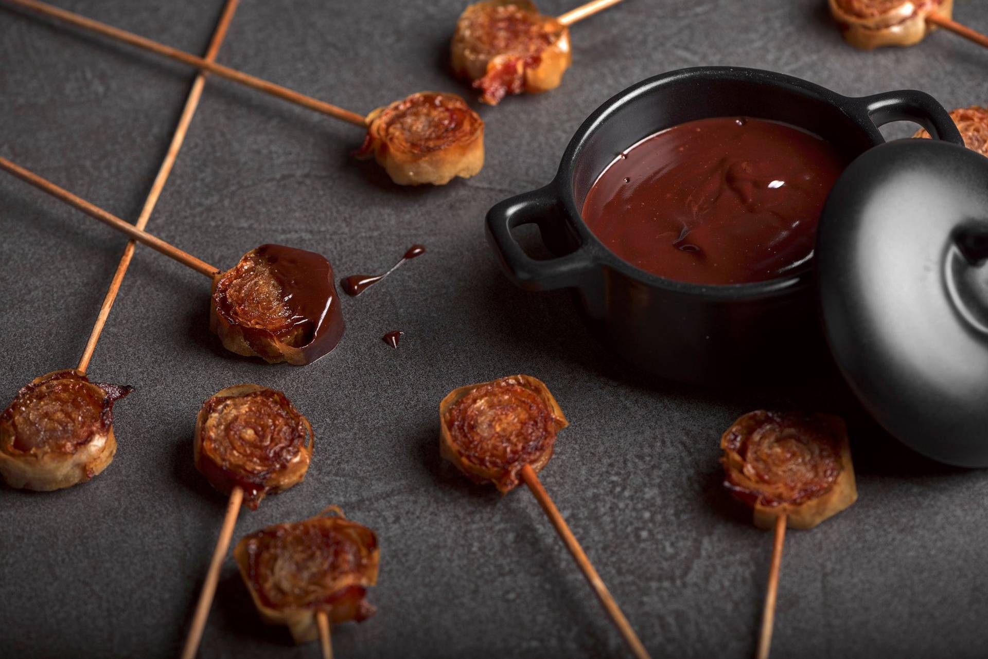 bacon and cinnamon lollipops with dark chocolate on a sapienstone top
