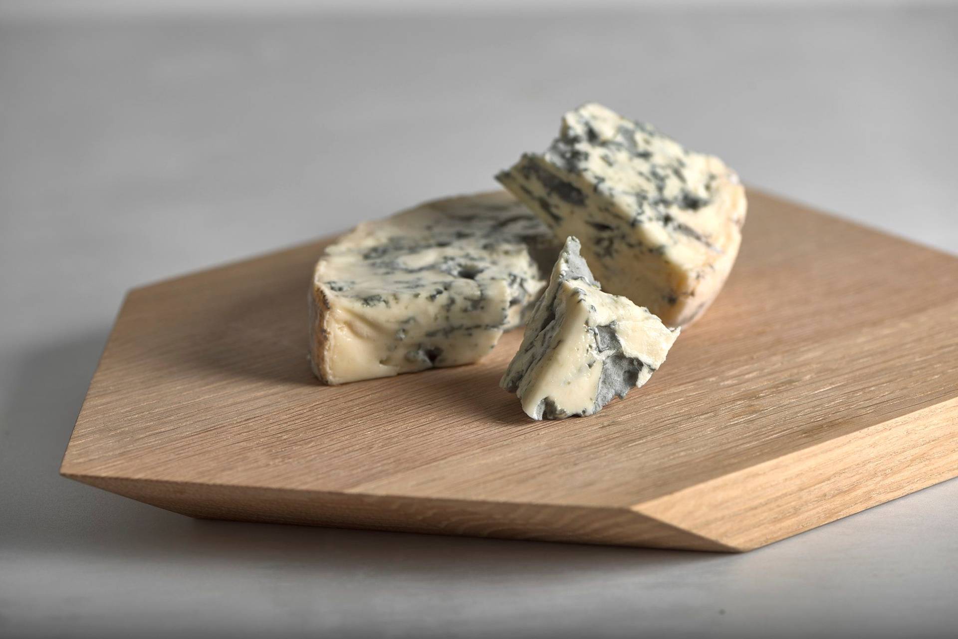 fourme d´ambert blue cheese on a wooden board on a white stone table
