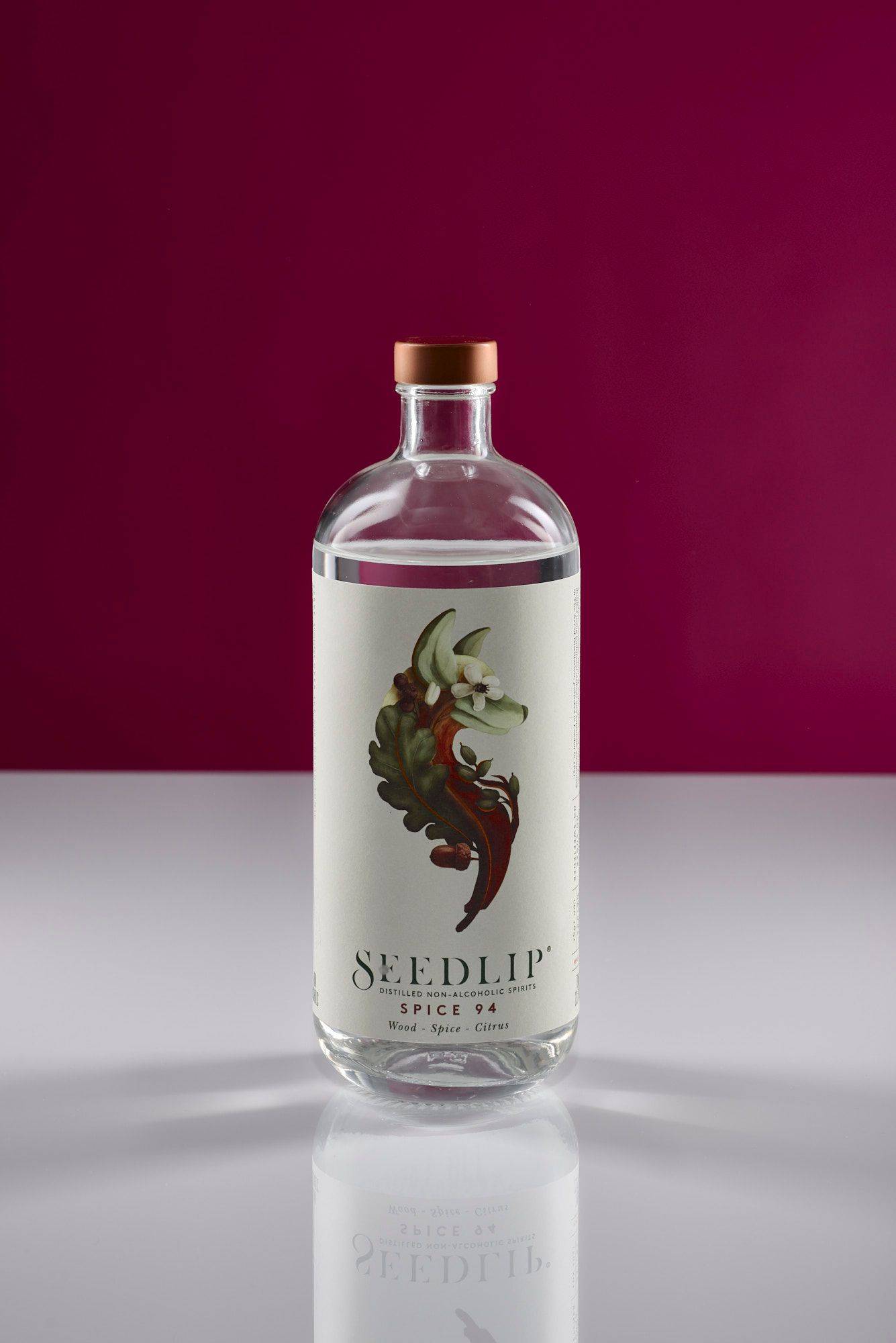 a bottle of non-alcoholic seedlip spice 94 with white and pink background