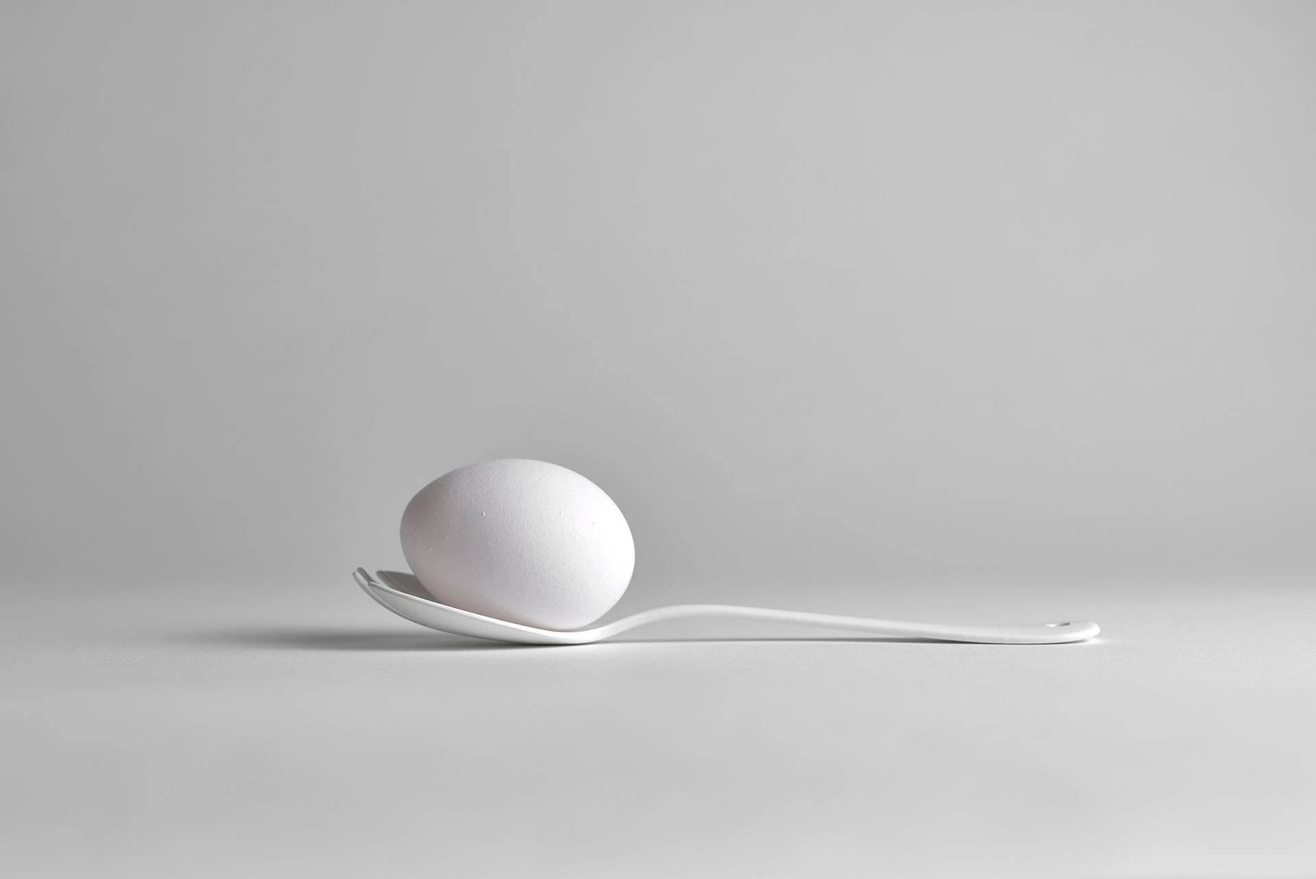 ein weißes ei auf einem weißen löffel mit weißem hintergrund