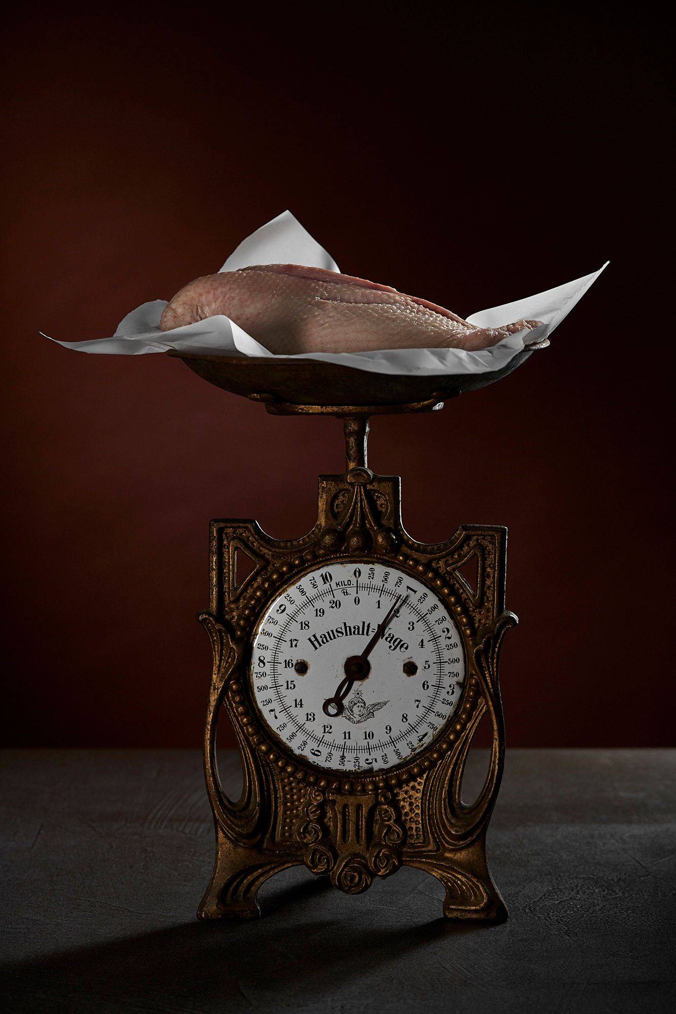 goose breast on vintage scale with brown background