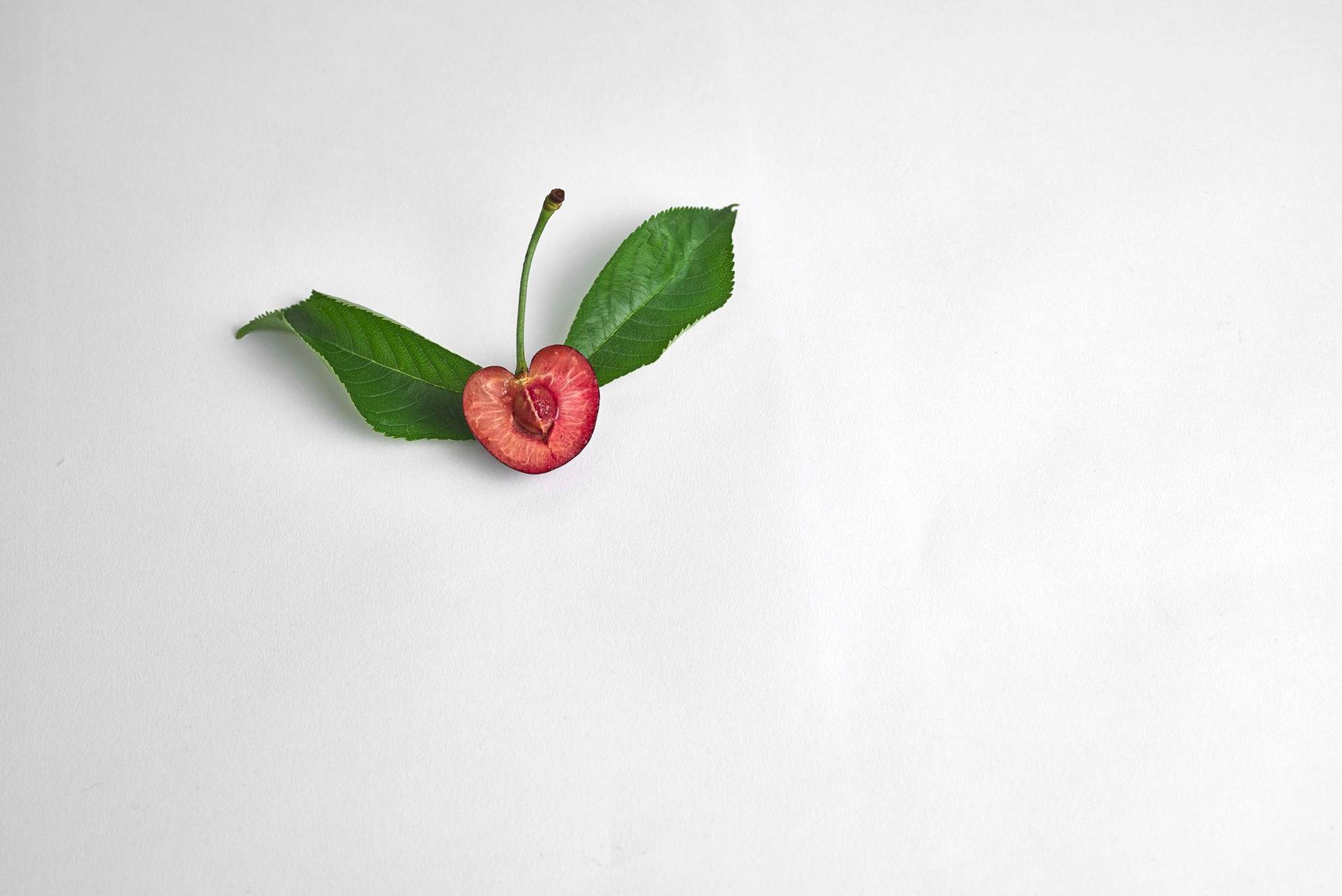 half a cherry with leaves with on white background