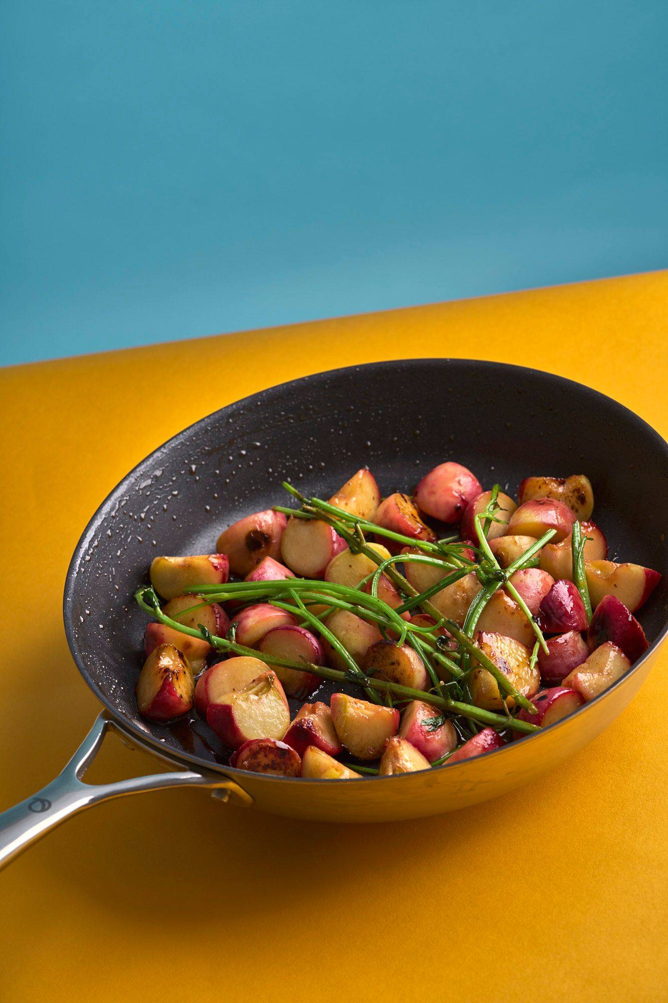 grilled peaches in an olav pan with yellow and blue background