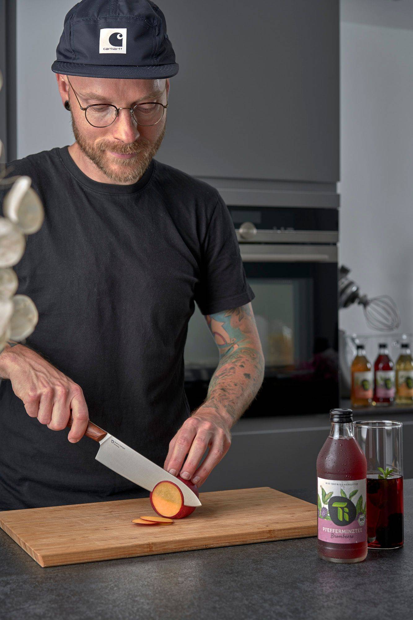 man cutting nectarine in home kitchen