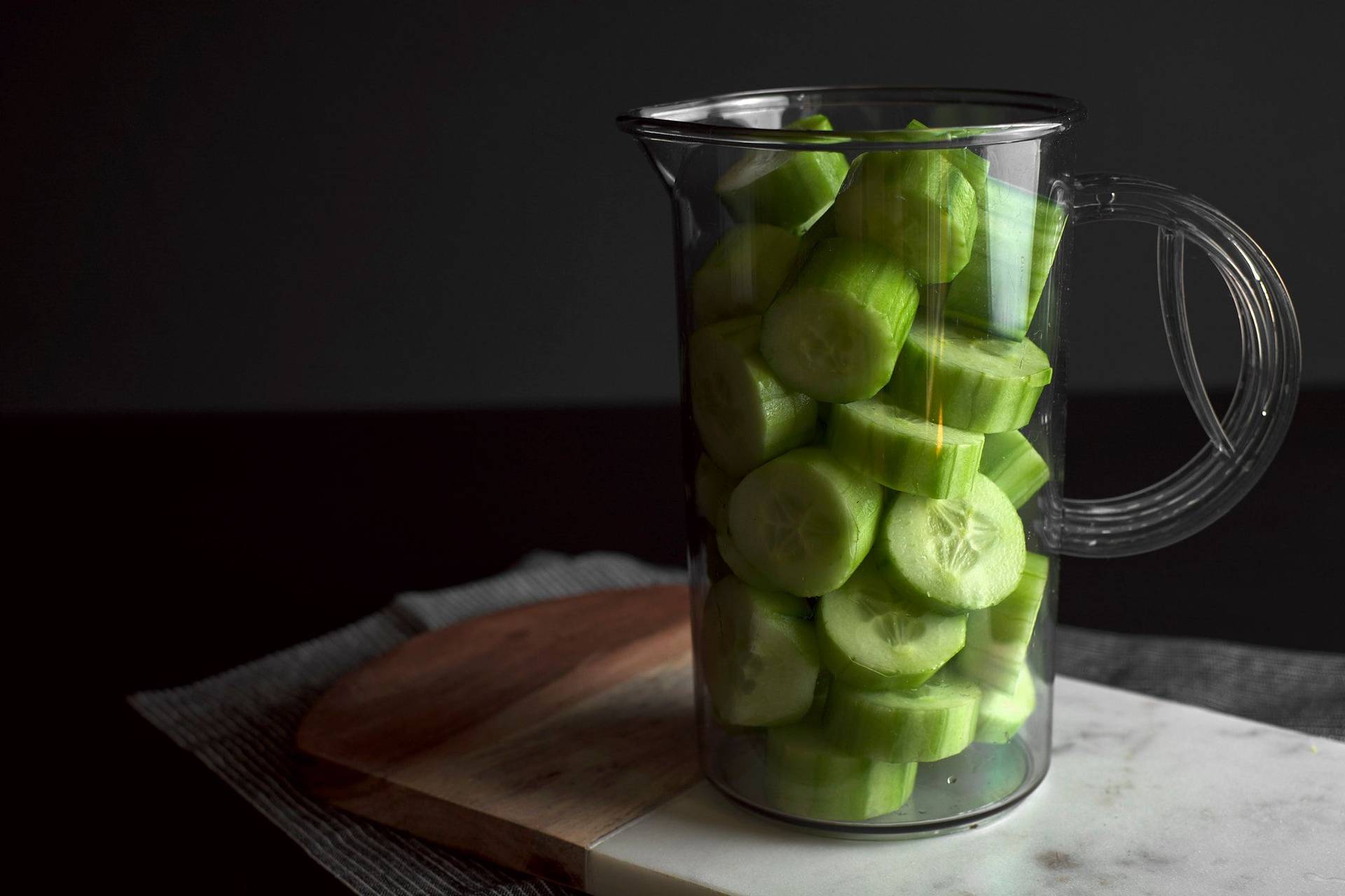 making cucumber lemonade on black background