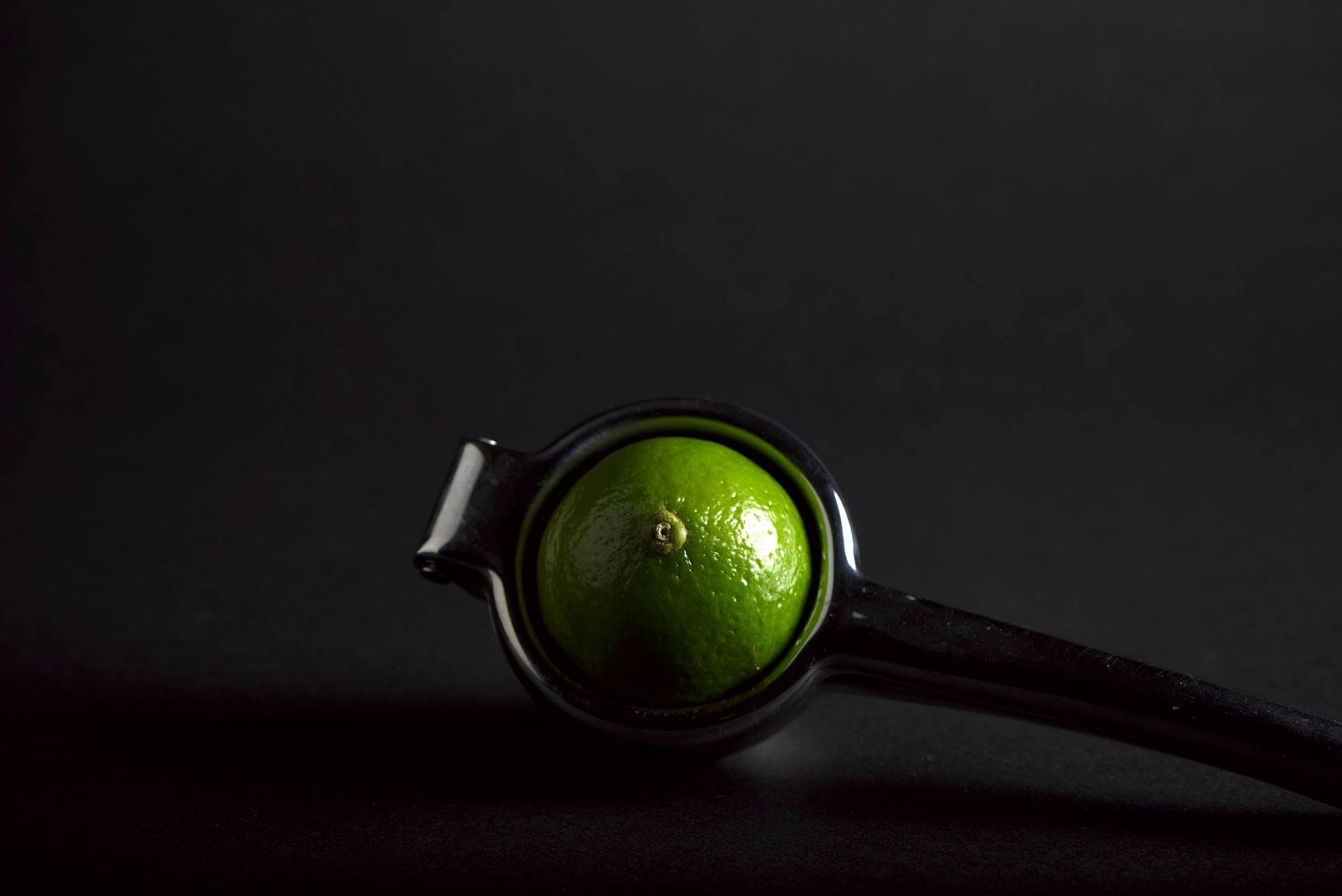 lime a lime in a hand press on black background