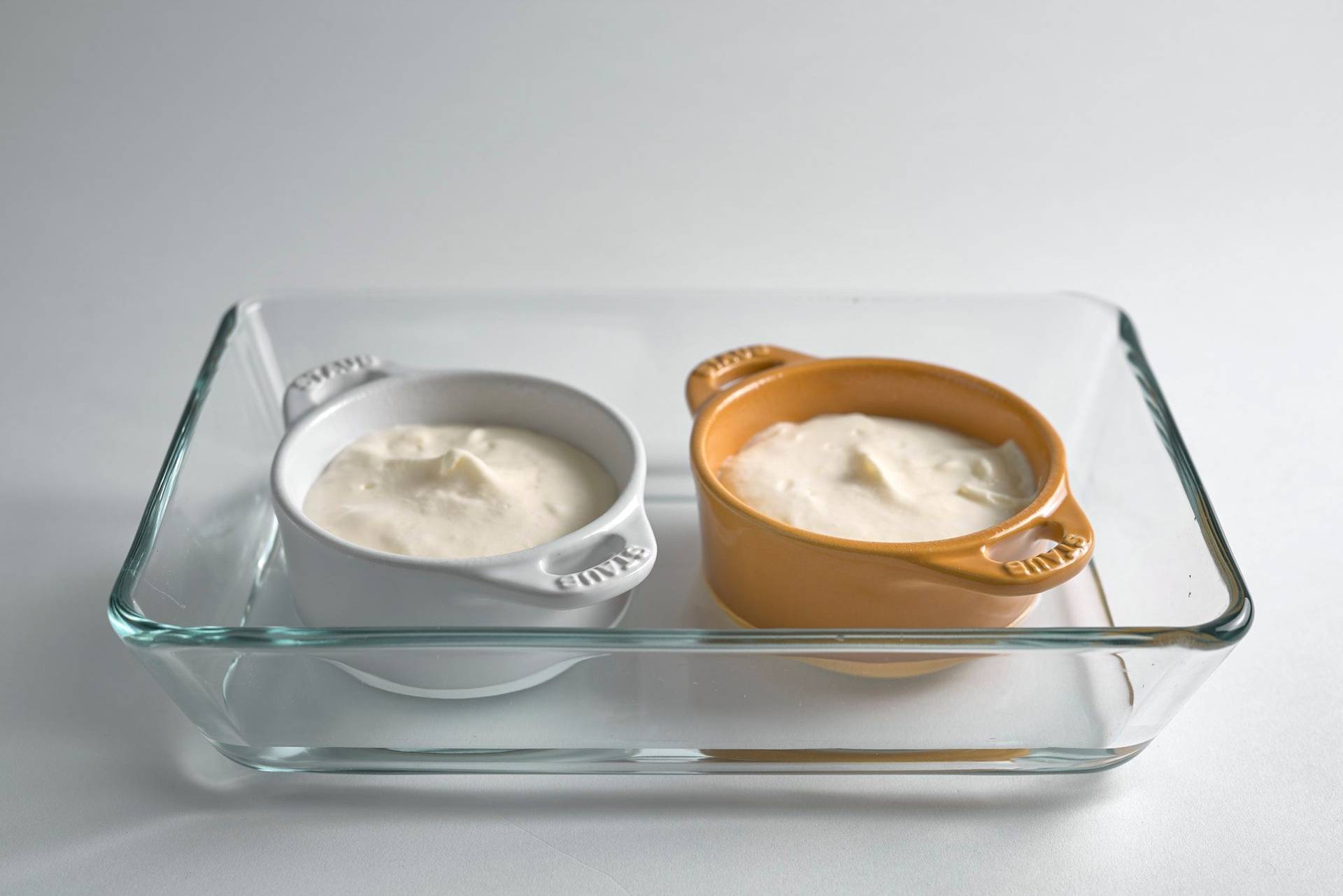 two raw cheesecake souffles in a glass cocotte  with white background