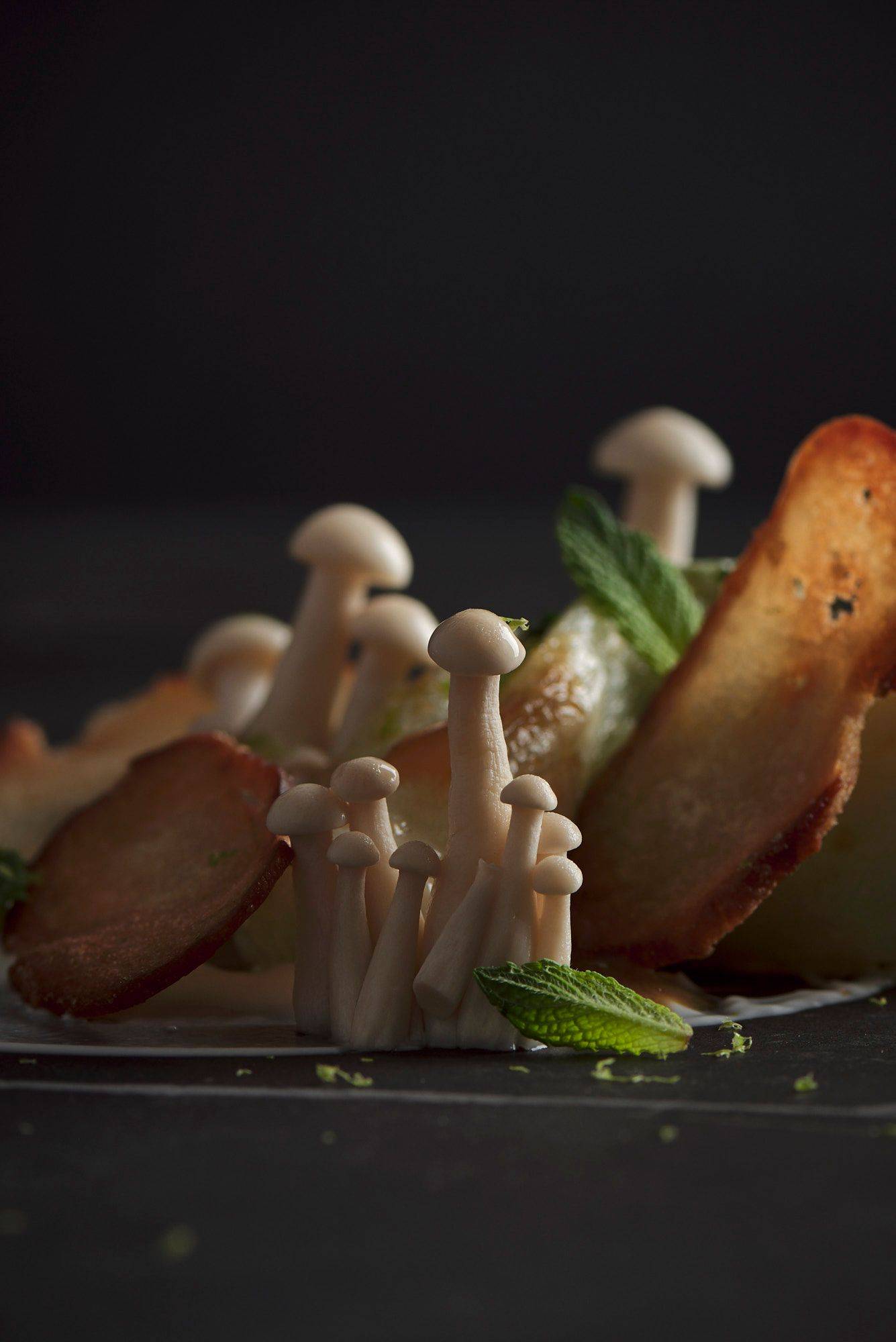 miso roasted pak choi with mushroom pickles and pretzel crisps on a gray sapienstone top