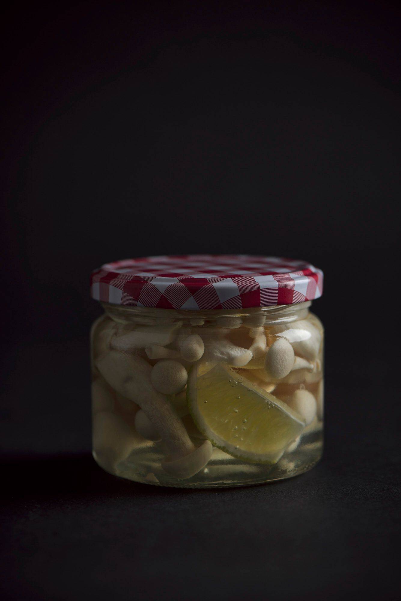 mushoom pickles in a jar on a gray sapienstone top