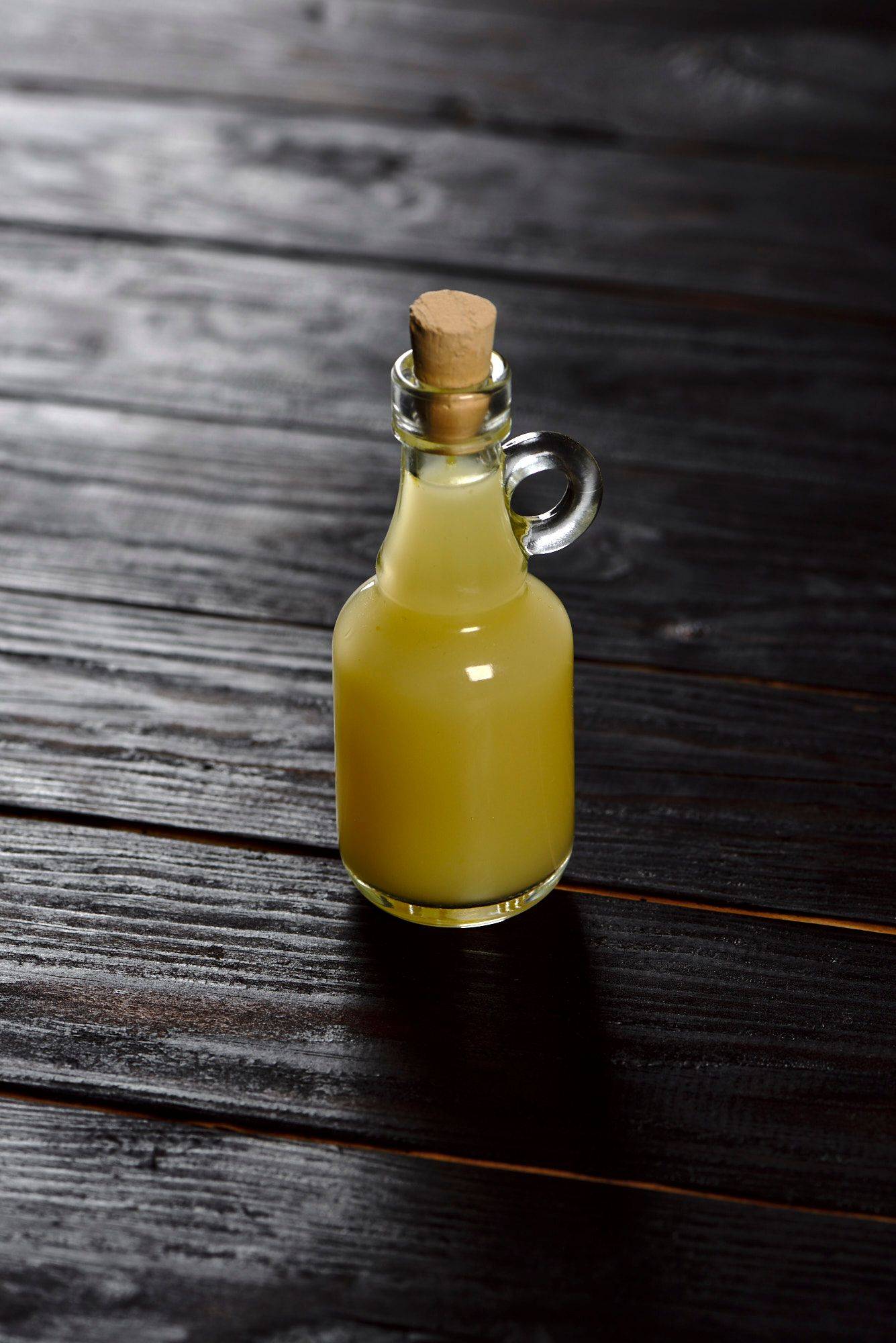 yuzu juice in a small glass bottle with black wooden background