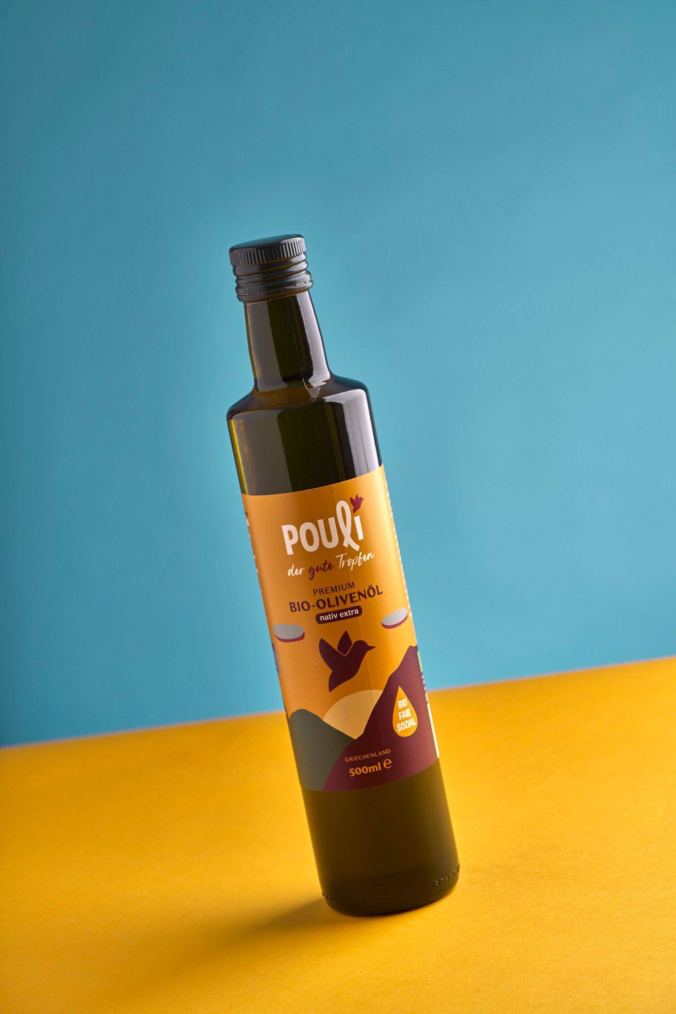 a bottle of pouli organic olive oil with yellow and blue background