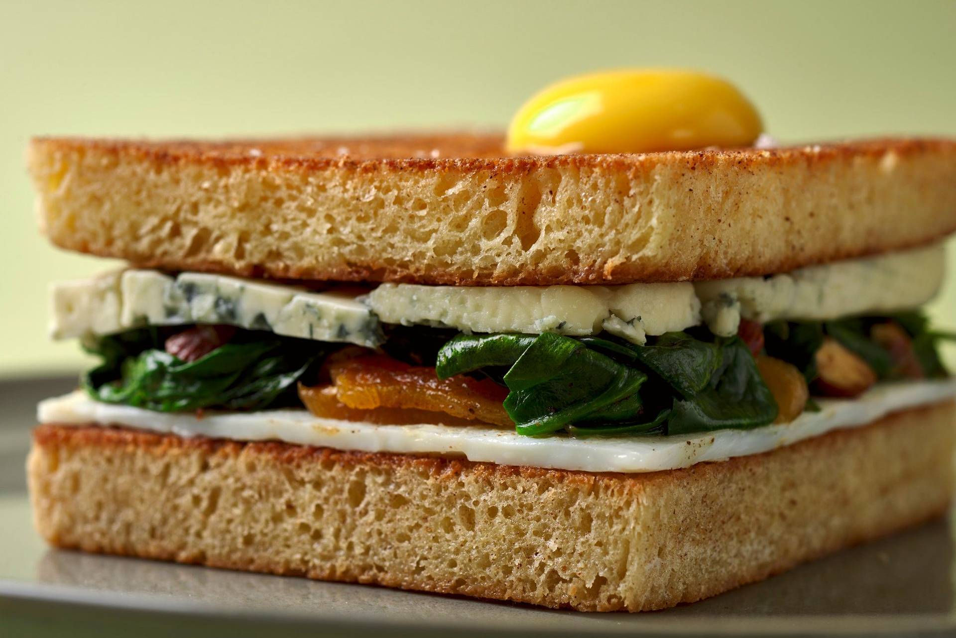easter bread sandwich on a gray plate with green background