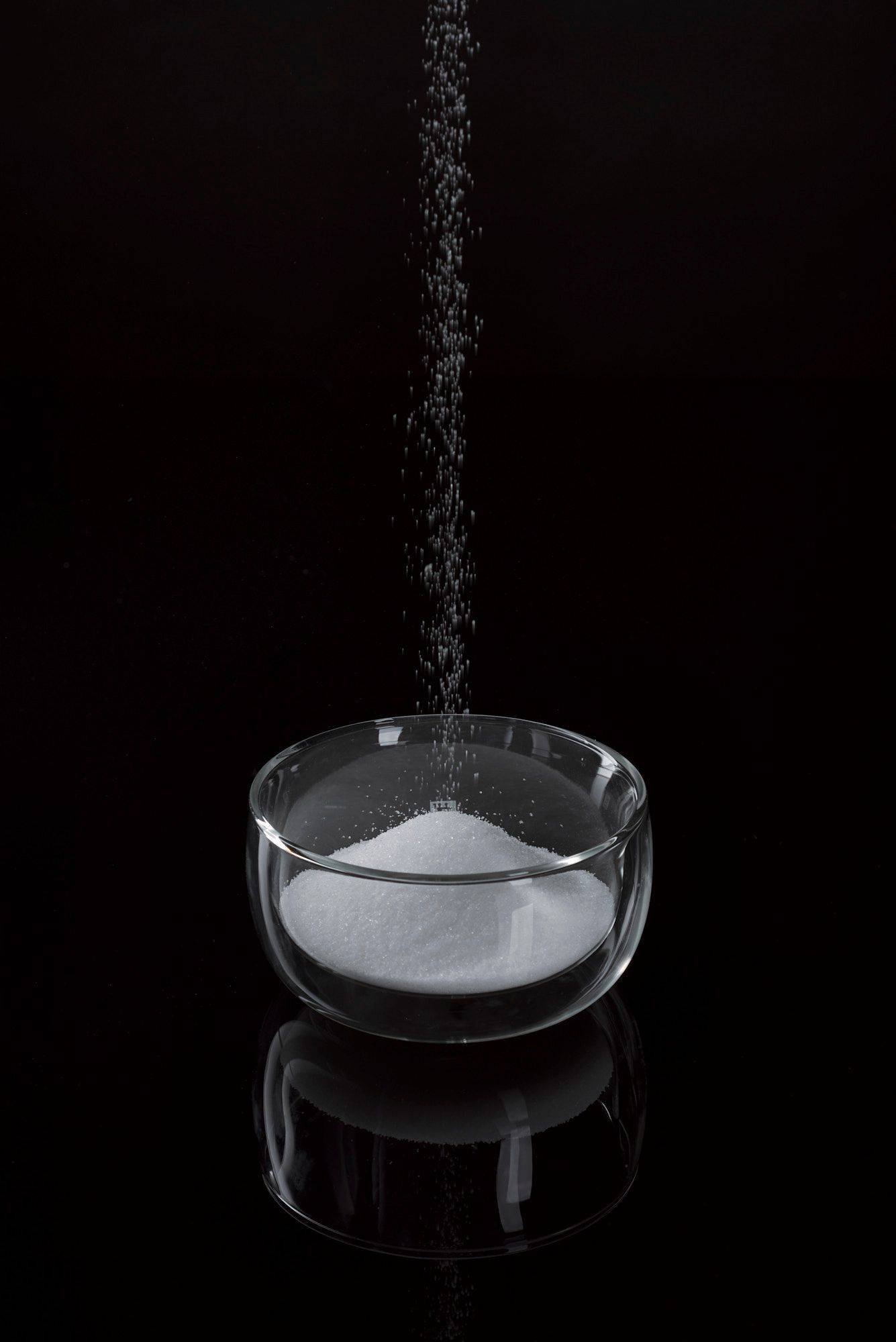 salz-zucker-mischung salz zucker mischung in einer glasschale mit schwarzem hintergrund