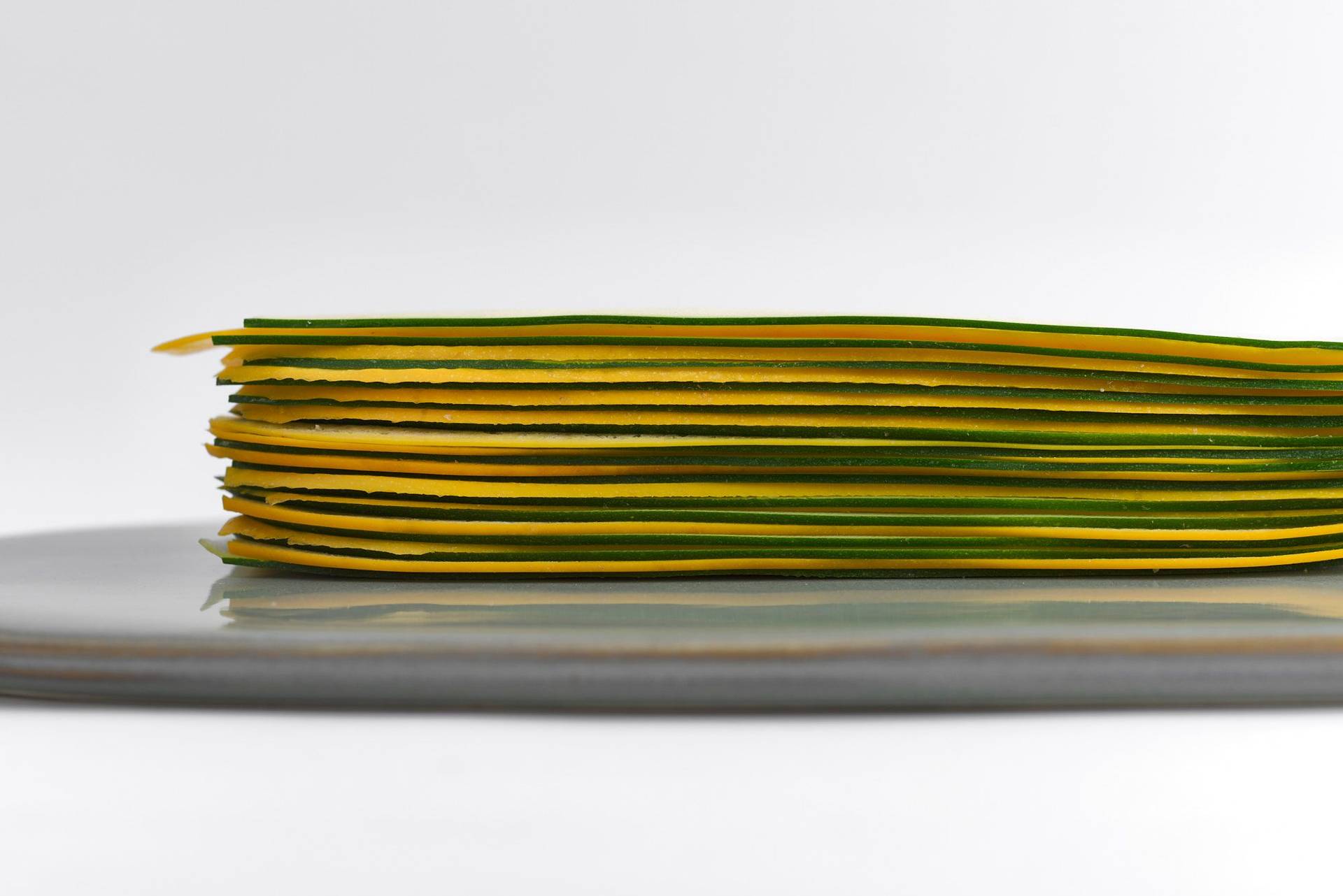 sliced-courgette sliced courgette mille feuille on a gray plate with white background