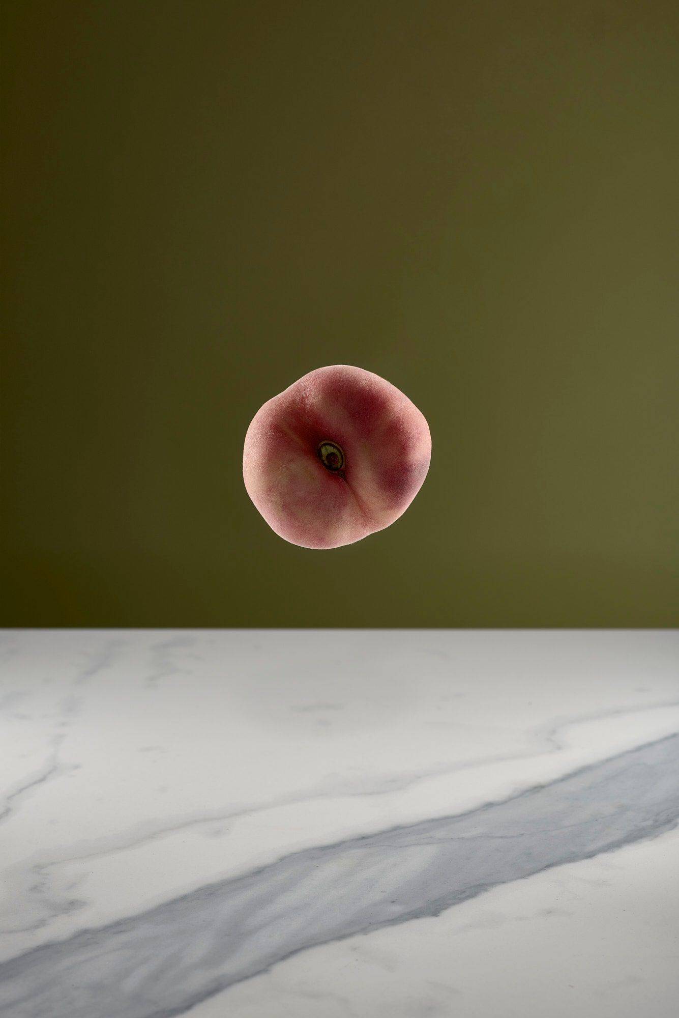 a white peach with a marbled sapienstone top and green background