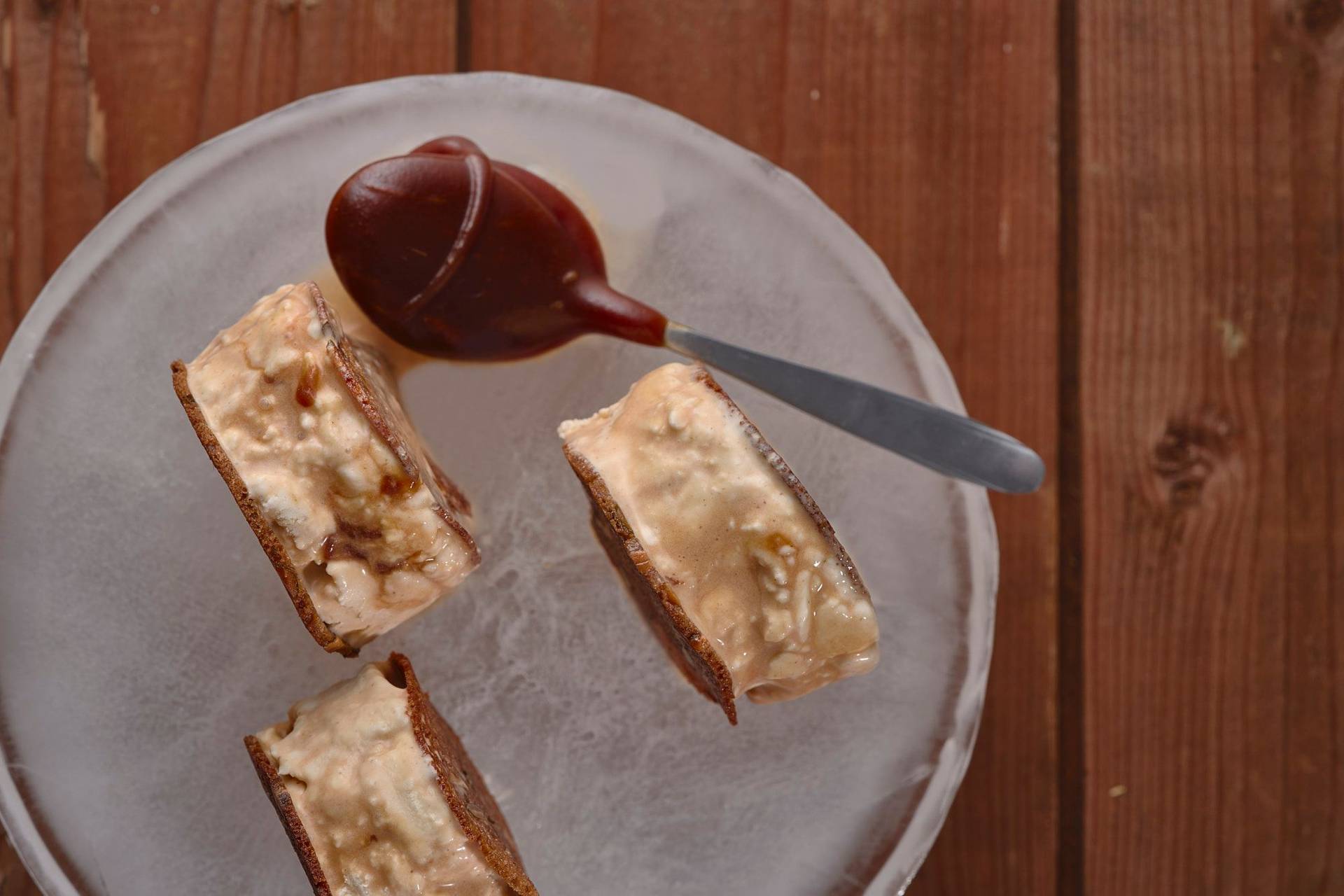 sourdough ice cream sandwich with salted caramel on an ice plate with wooden table