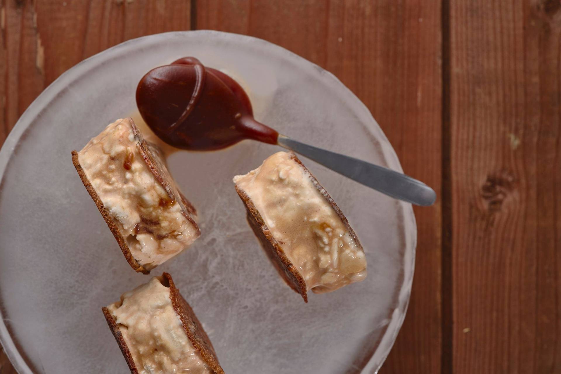 sauerteig eiscreme sandwich mit salzkaramell auf einem eis teller auf holztisch