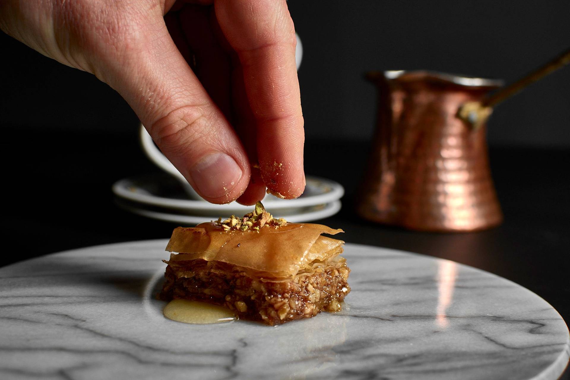 baklava with hazelnuts and walnuts on a marble plate with black background