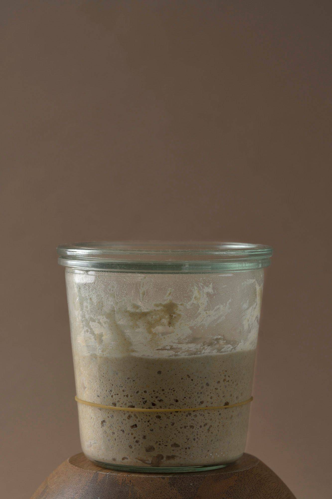 sourdough-starter a jar of sourdough starter with brown background