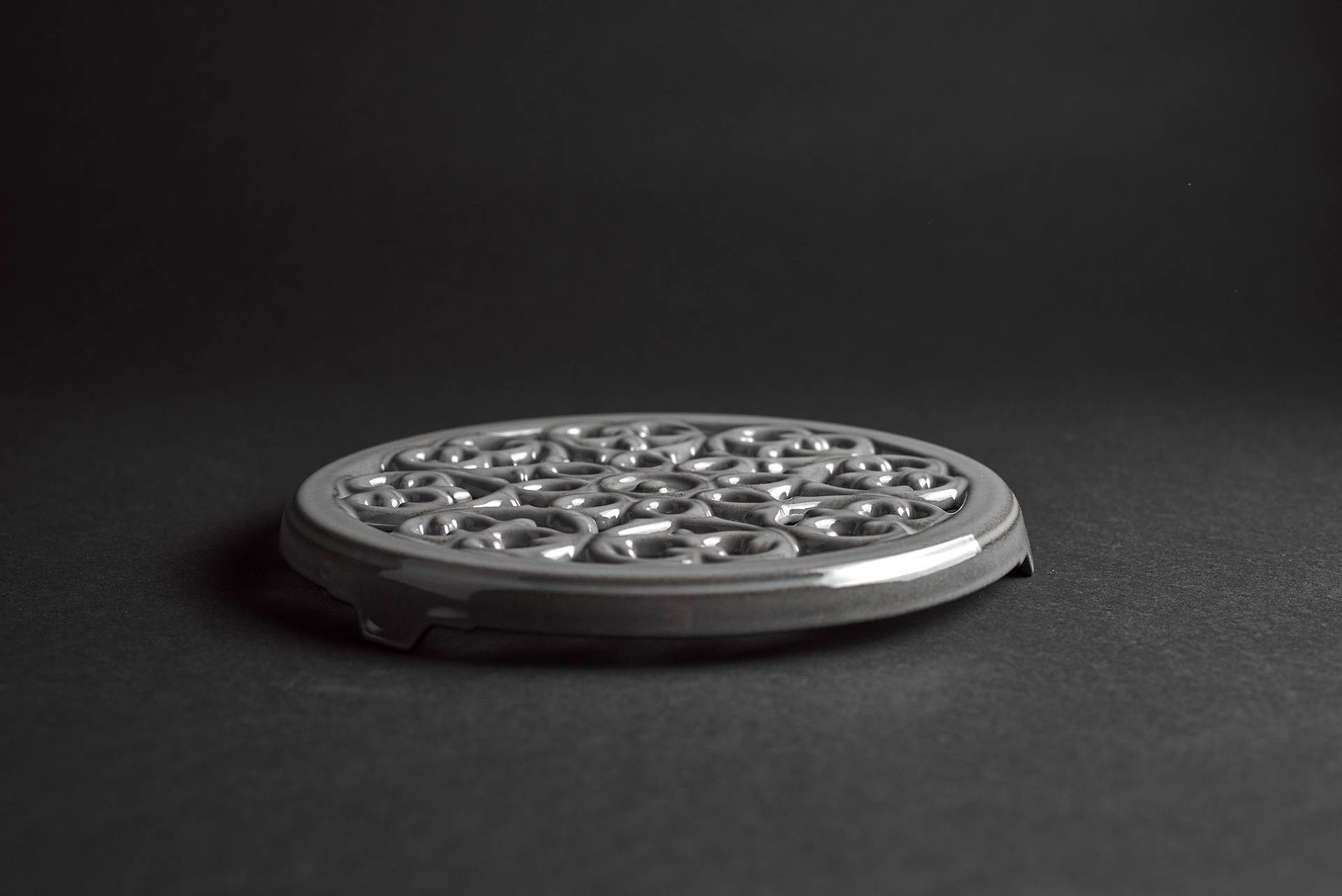 gray staub la cocotte cast iron coaster on black background