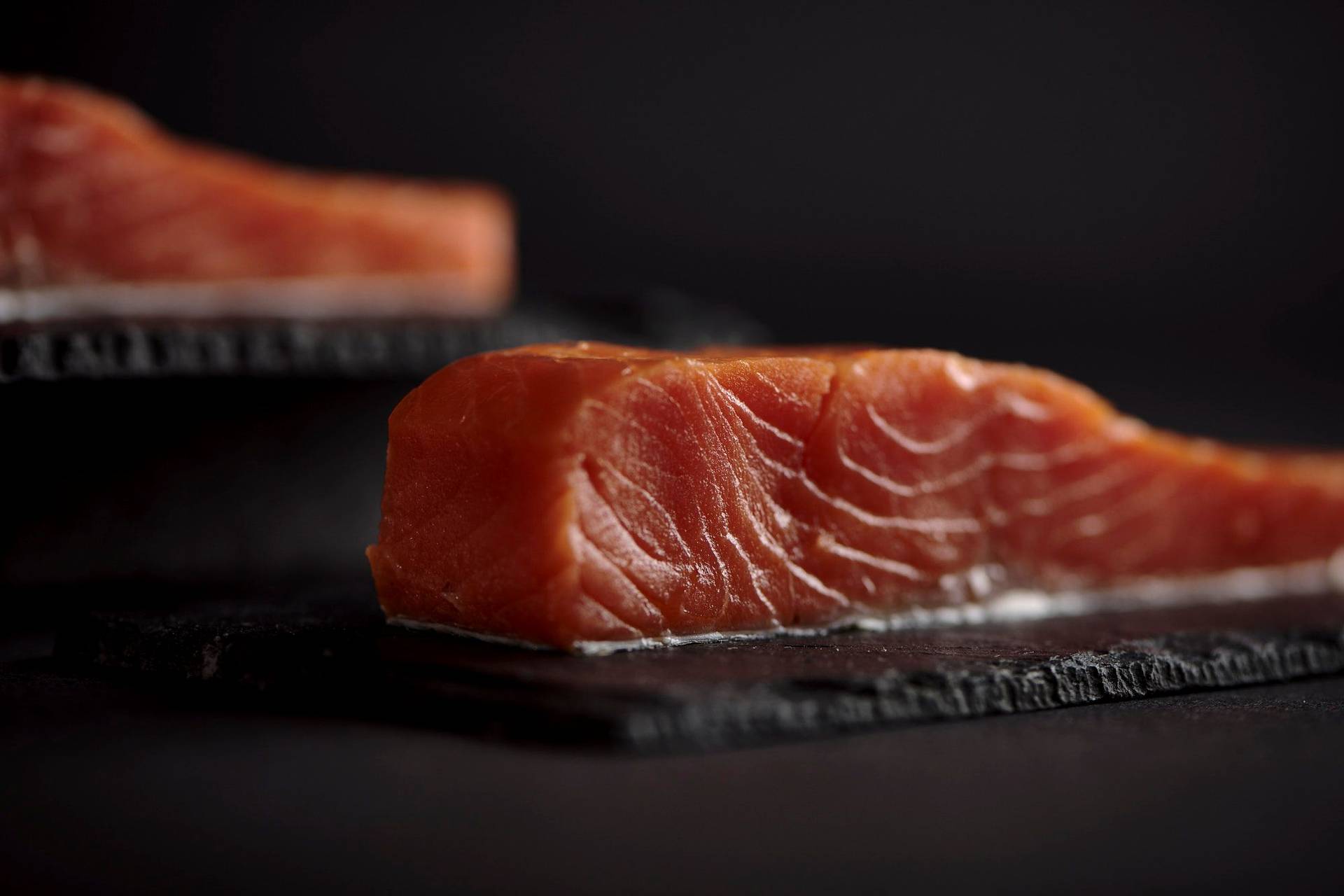 cured-salmon two pieces of cured salmon with black background