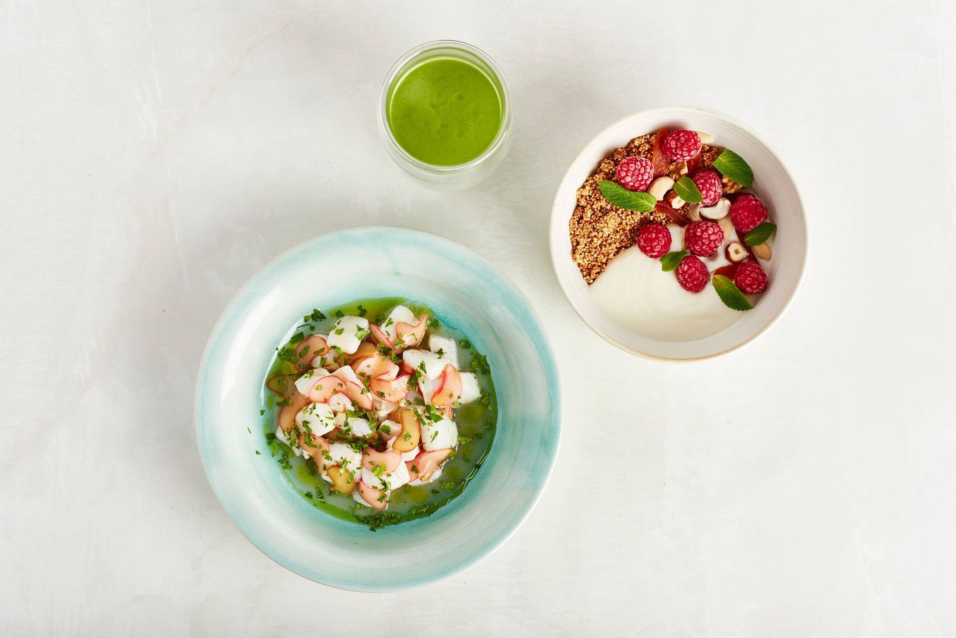 katerfrühstück aus sauerampfer smoothie amaranth bowl und rhabarber ceviche auf weißem hintergrund