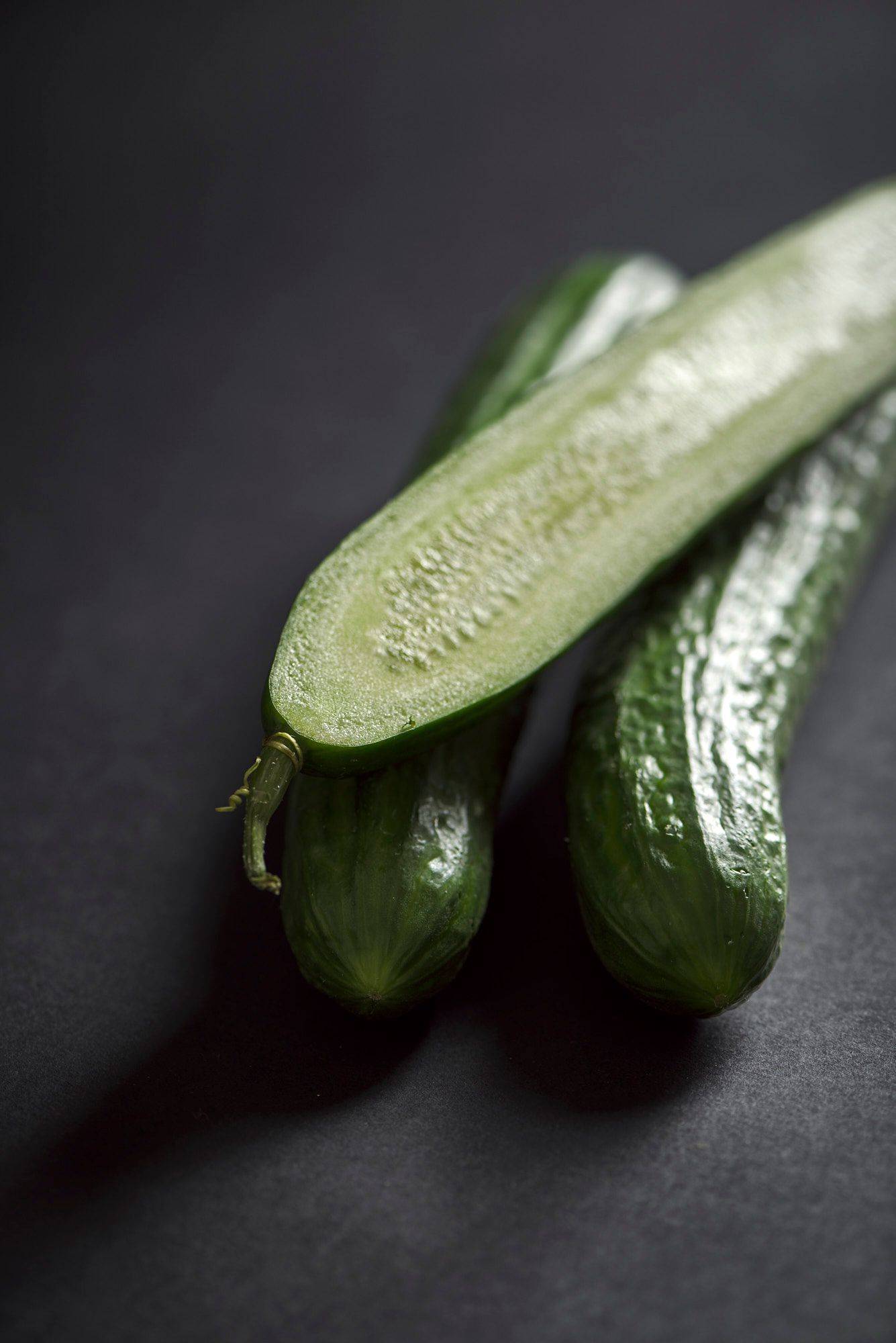 three cucumbers on black background