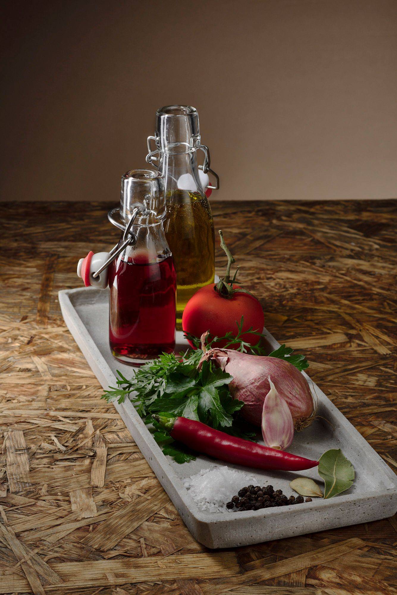 chimichurri ingredients on a concrete plate with brown wooden background