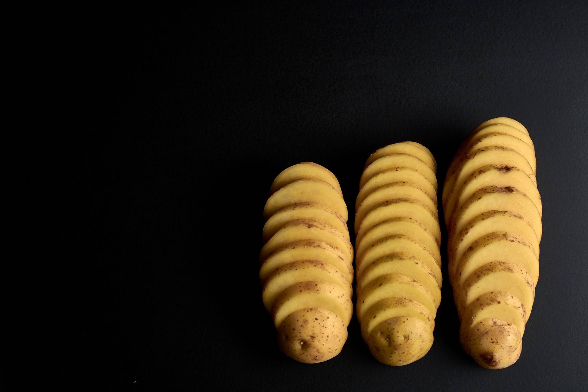 sliced potatoes on black background