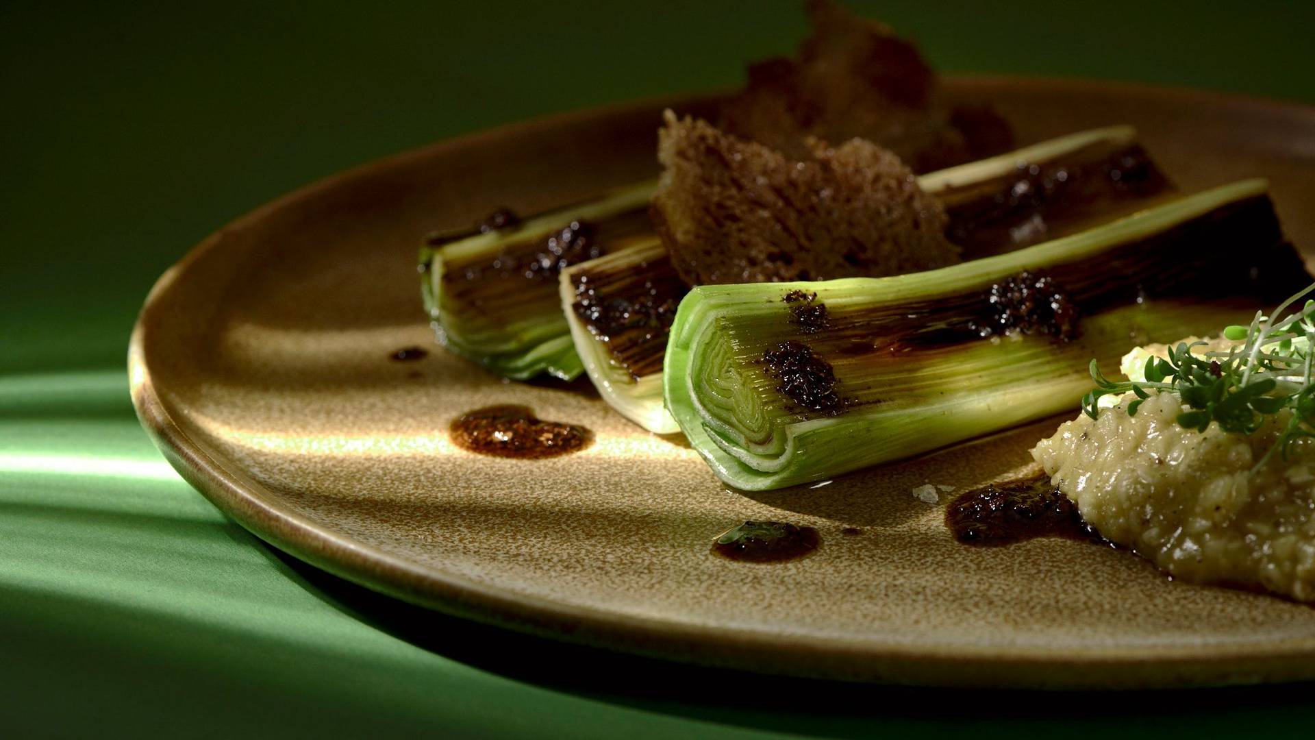 roasted-leek-with-passion-fruit-porridge-and-coffee-breakfast roasted leek with passion fruit porridge and coffee breakfast on a brown ceramic plate with green background