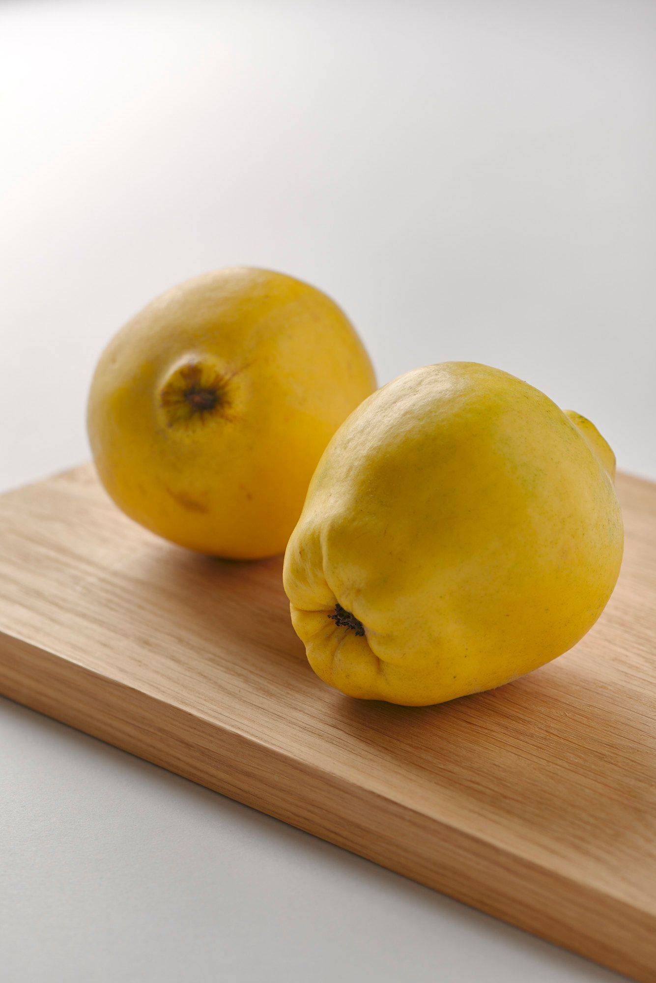 quince on a wooden board with white background