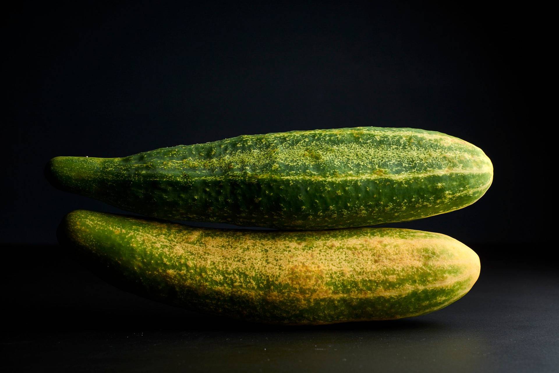 two cucumbers on black background