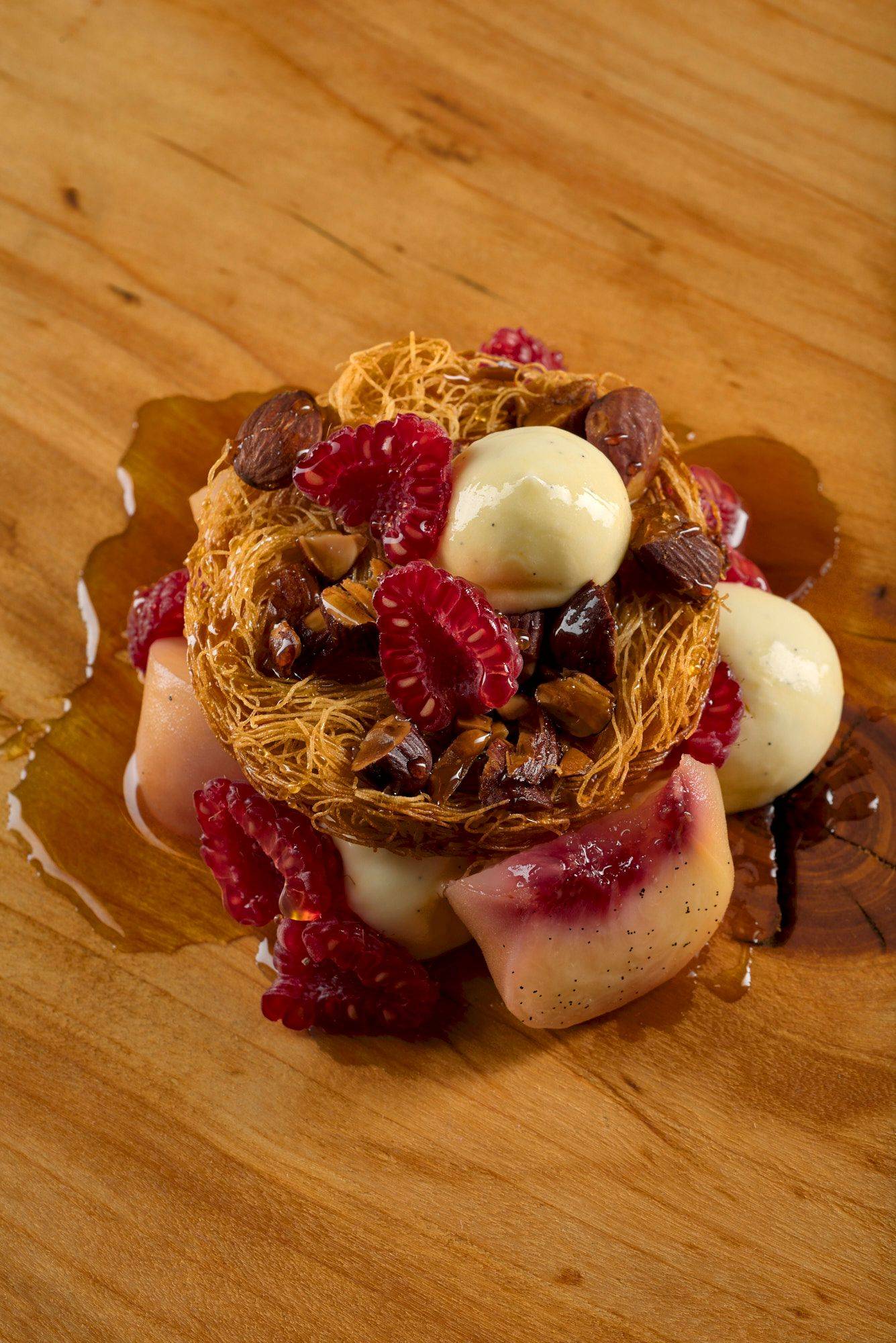 pfirsich melba dessert auf einem holzteller mit marmoriertem sapienstone top 