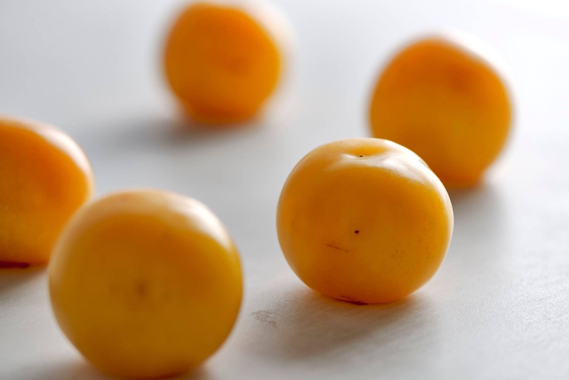 five yellow plums on a white sapienstone top