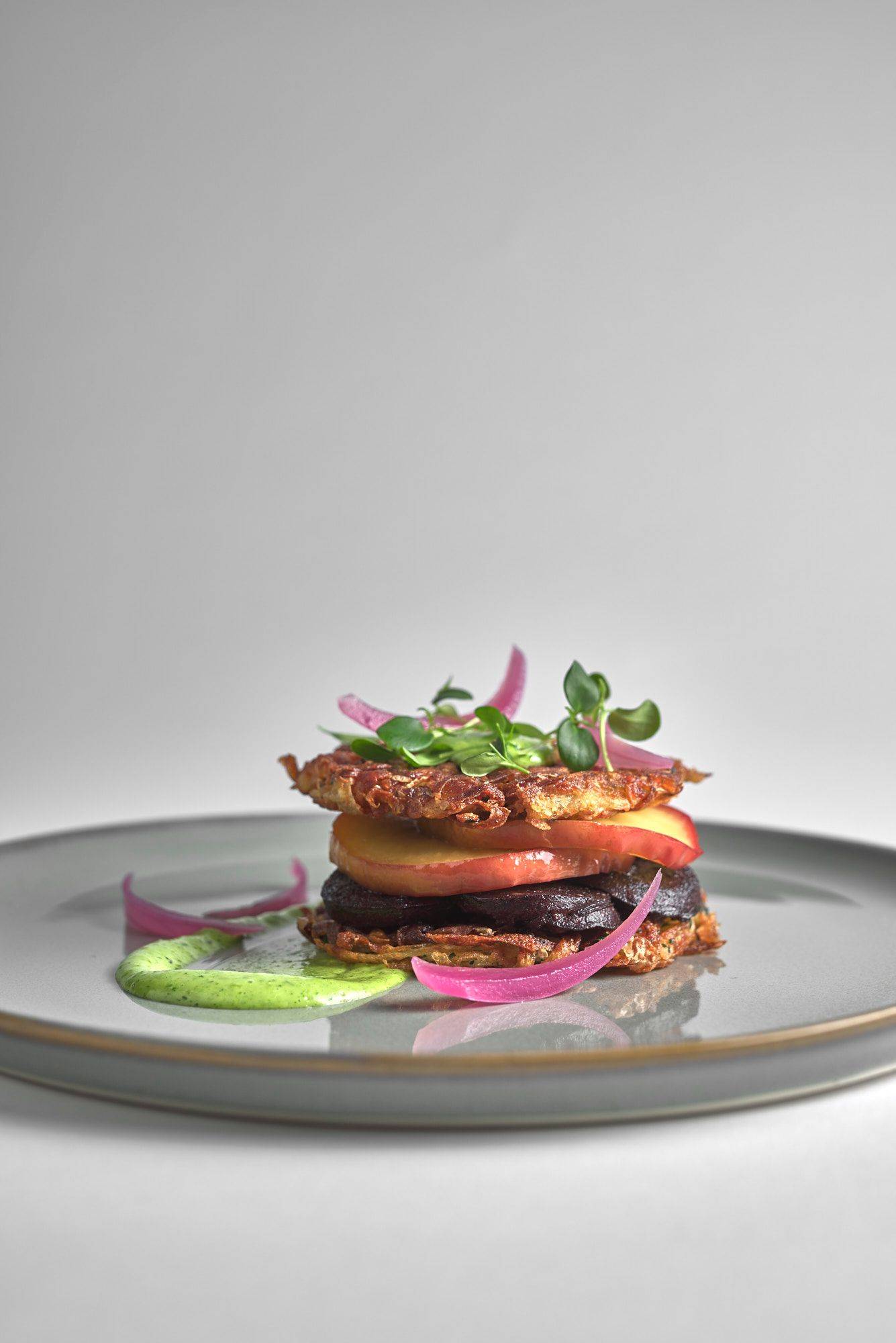 heaven and earth burger on a gray plate with white background