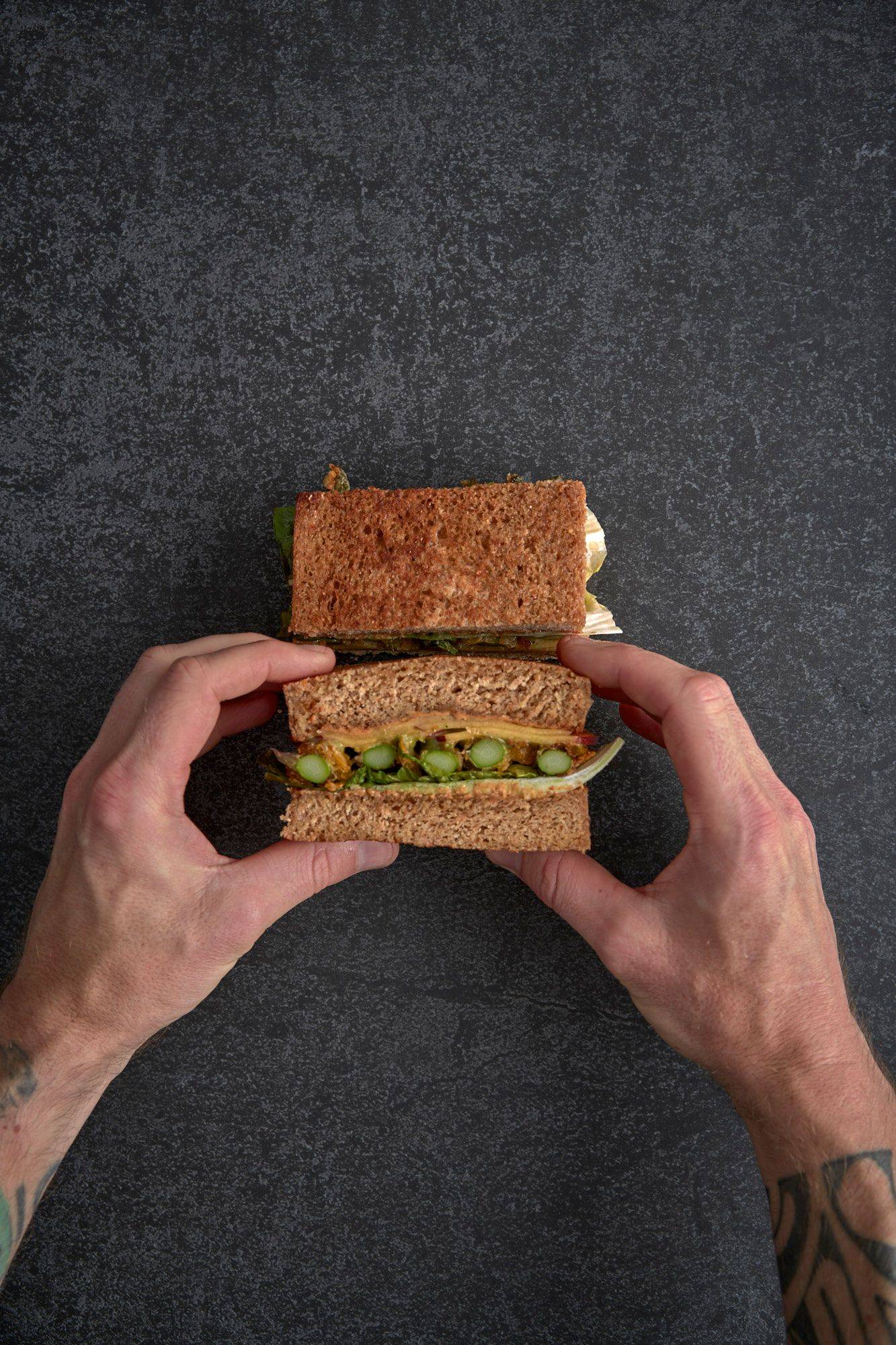 assembling-a-vegetarian-asparagus-katsu-sando-with-nectarine-and-mint-mayonnaise assembling a vegetarian asparagus katsu sando with nectarine and mint mayonnaise on a gray sapienstone top