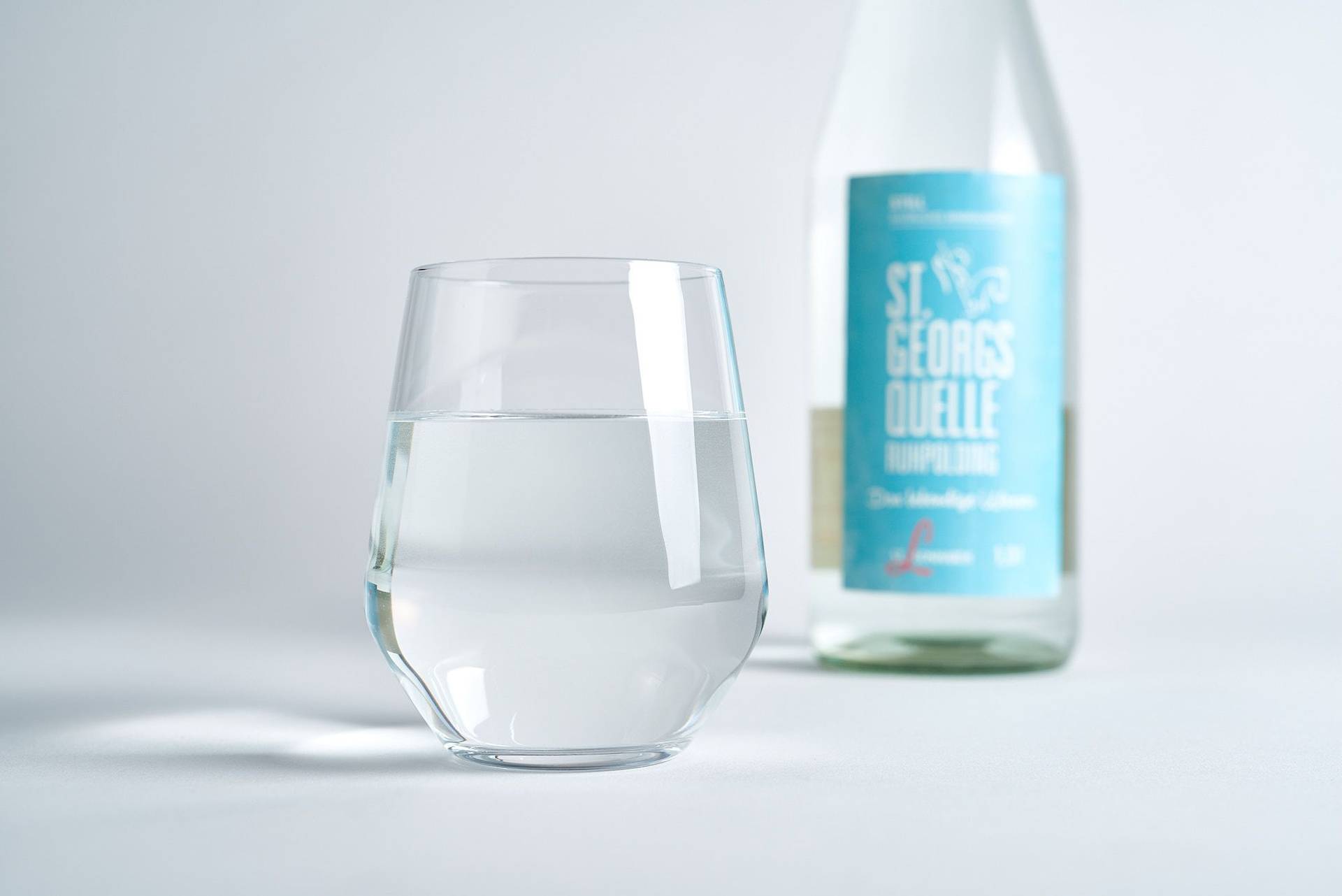 mineral water bottle and glass on white background