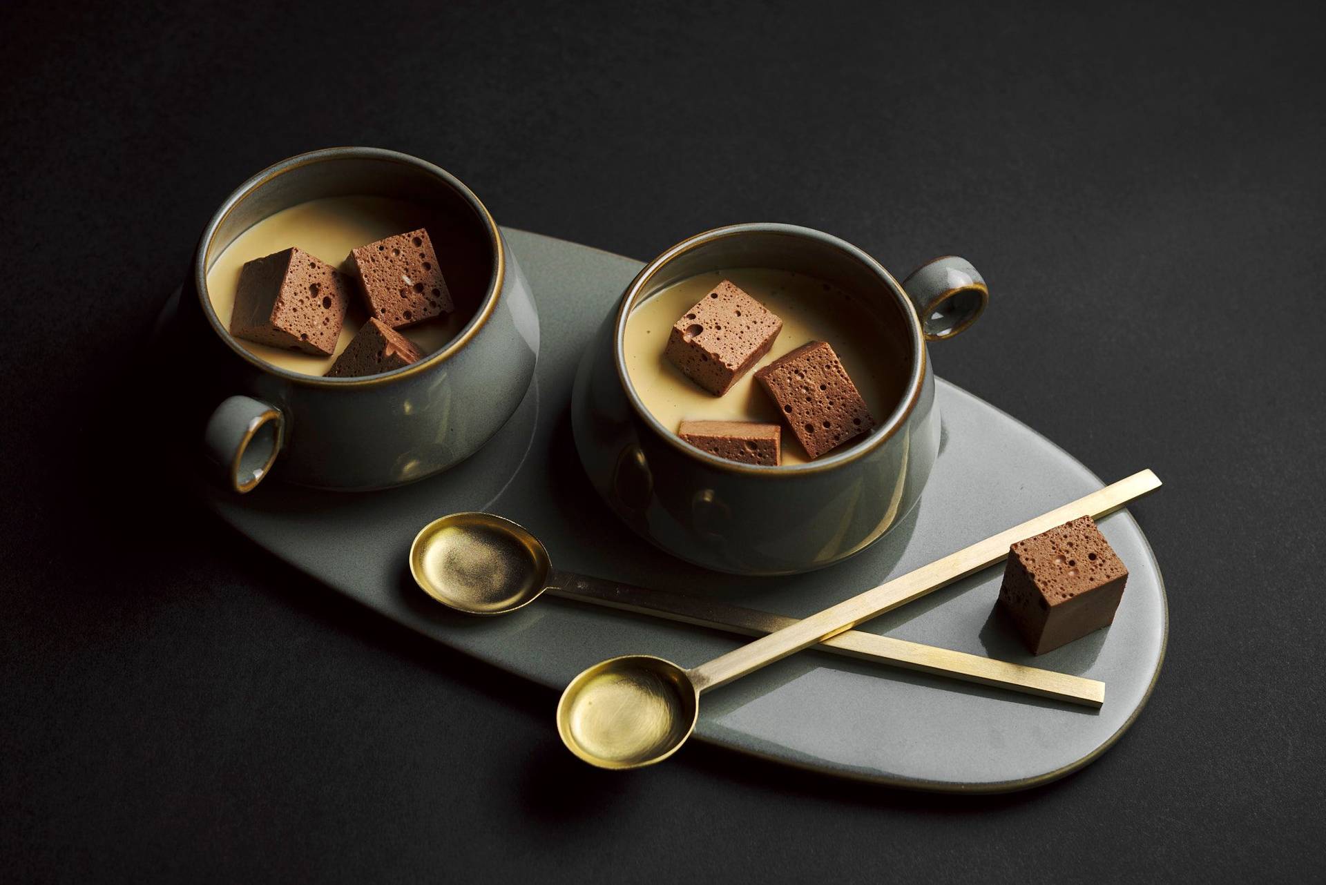 homemade eggnog with chocolate marshmallows on a gray plate with black background