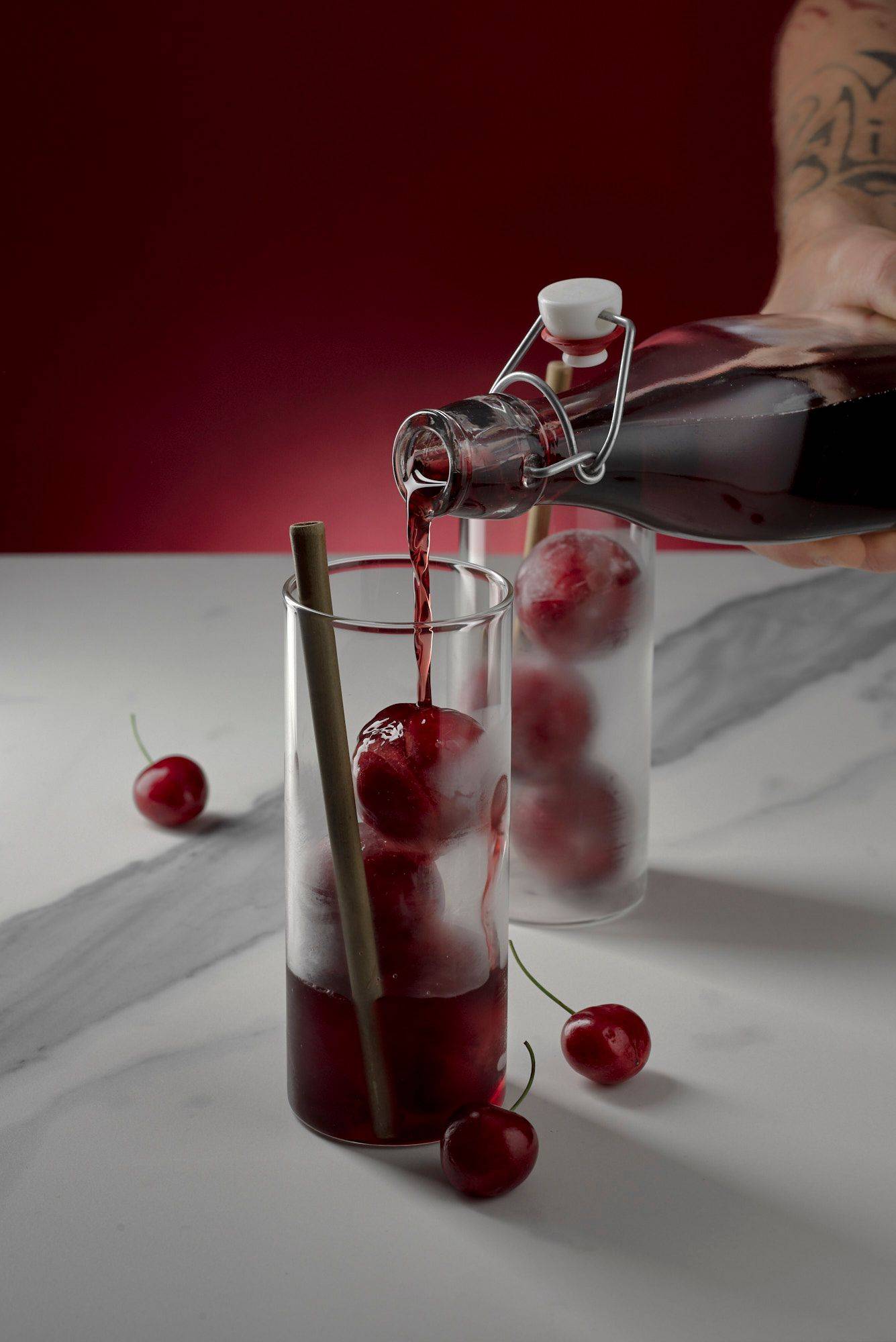 cherry-and-rice-cooler-with-sake cherry and rice cooler with sake on marbled sapienstone top with red background