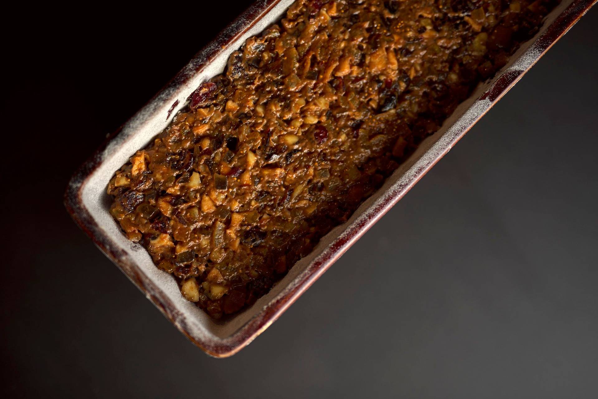 rohes-fruechtebrot rohes früchtebrot in einer vintage backform mit schwarzem hintergrund