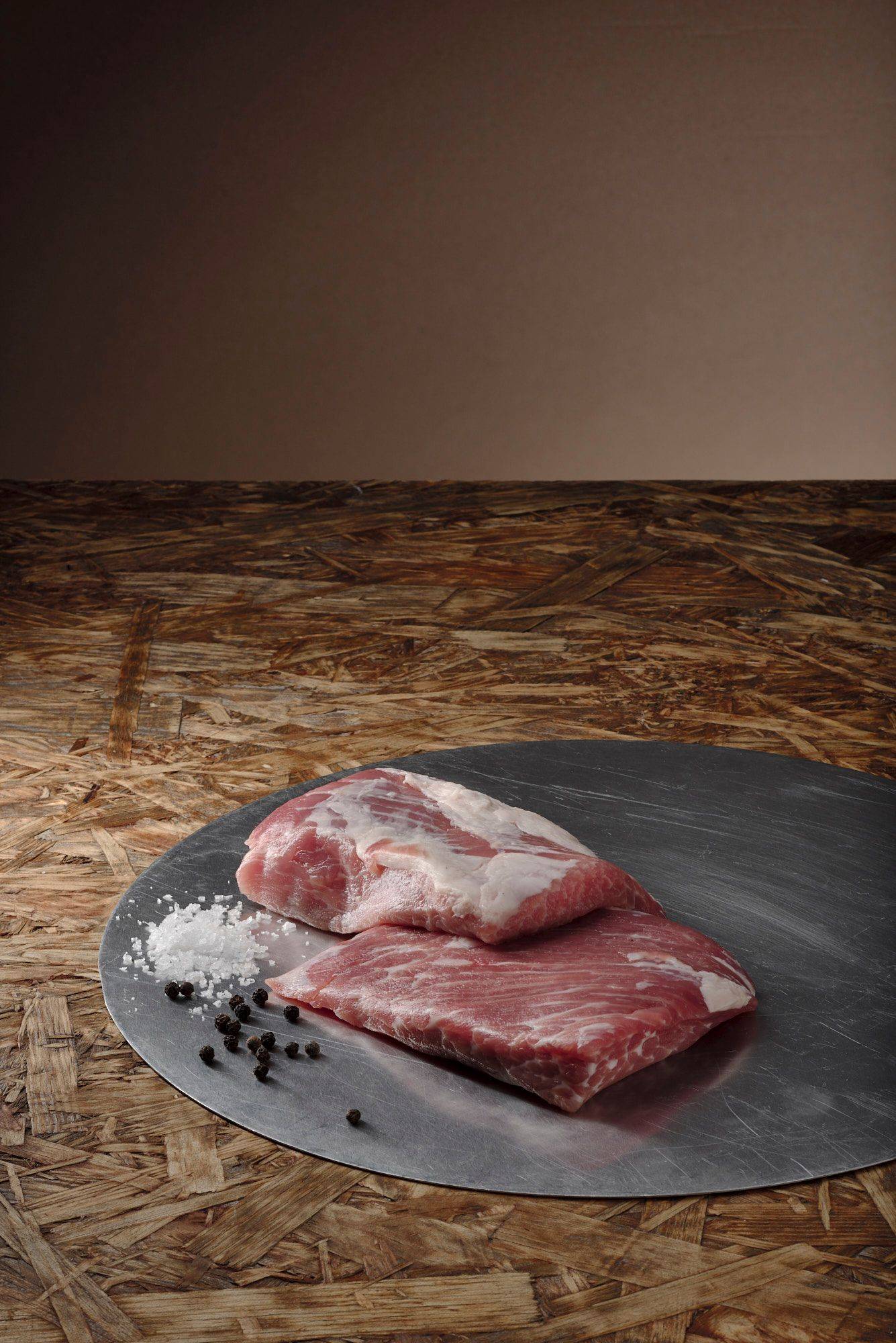 pork-secreto pork secreto on a metal plate with brown wooden background