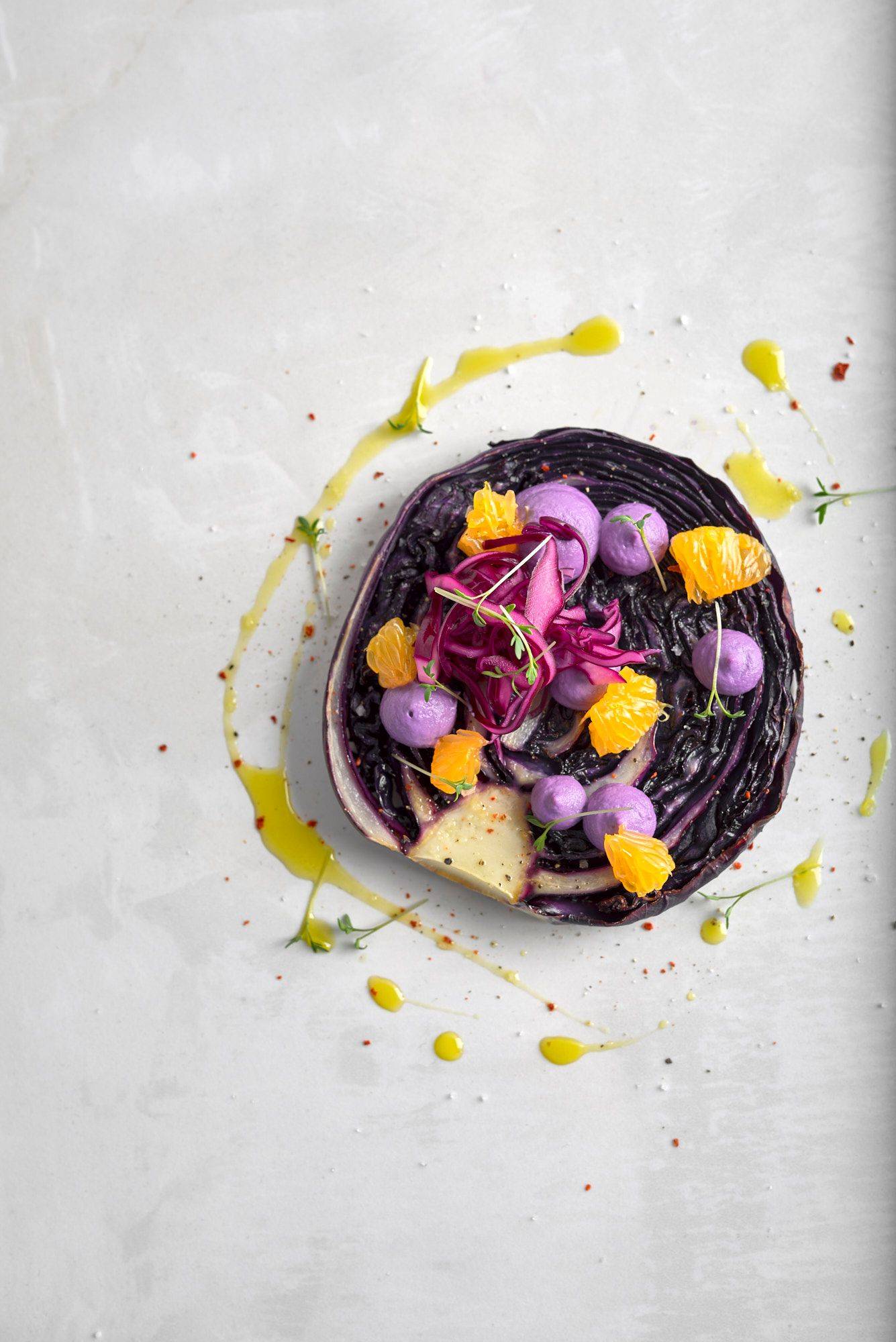 vegan red cabbage steak with cashew cream and tangerines on a white sapienstone top