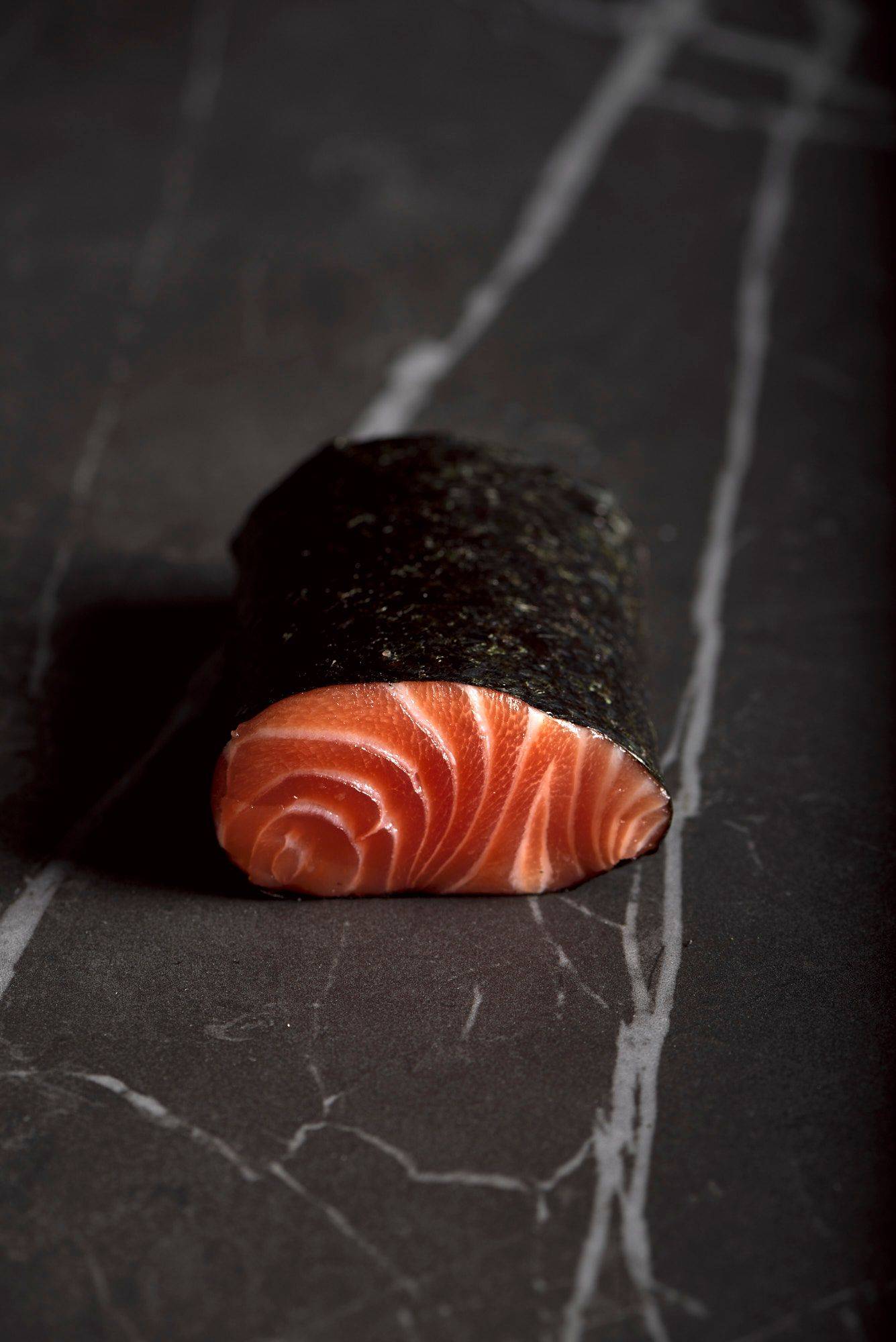 ein lachs loin in nori blatt gewickelt auf grauem sapienstone top