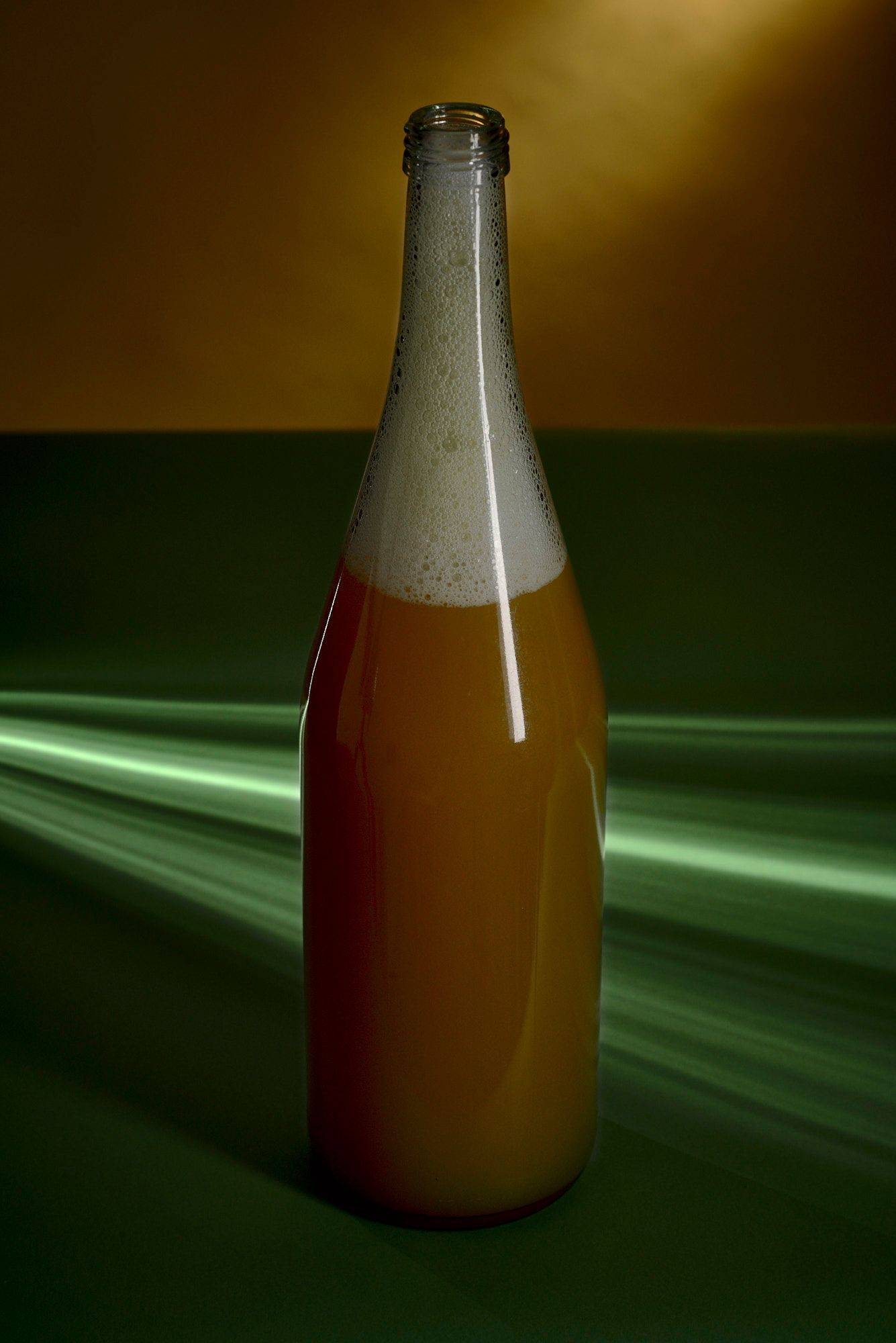 eine glasflasche mit passionsfruchtsaft mit grün gelbem hintergrund