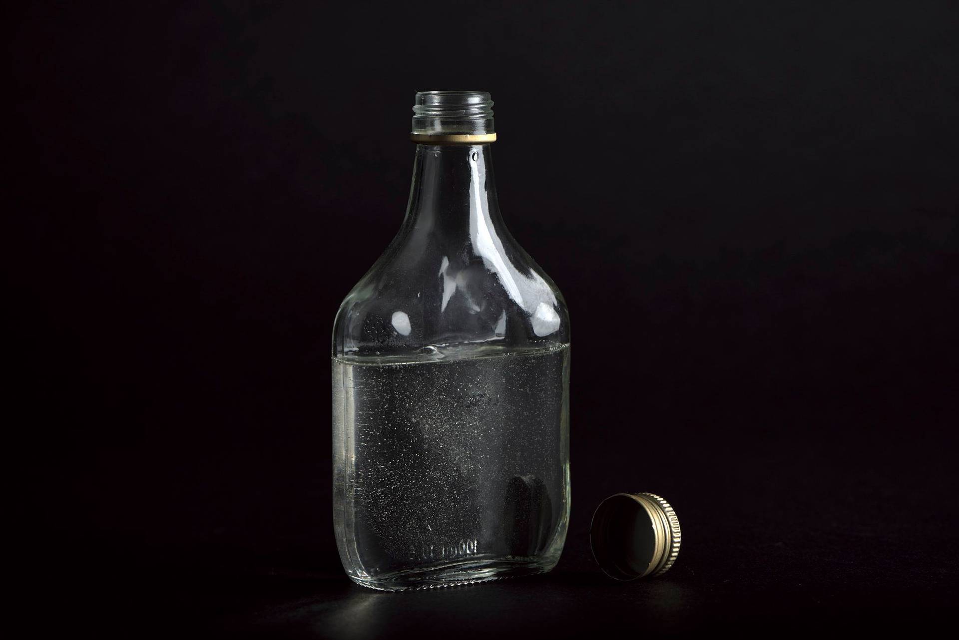 sugar-syrup a glass bottle of sugar syrup on black background