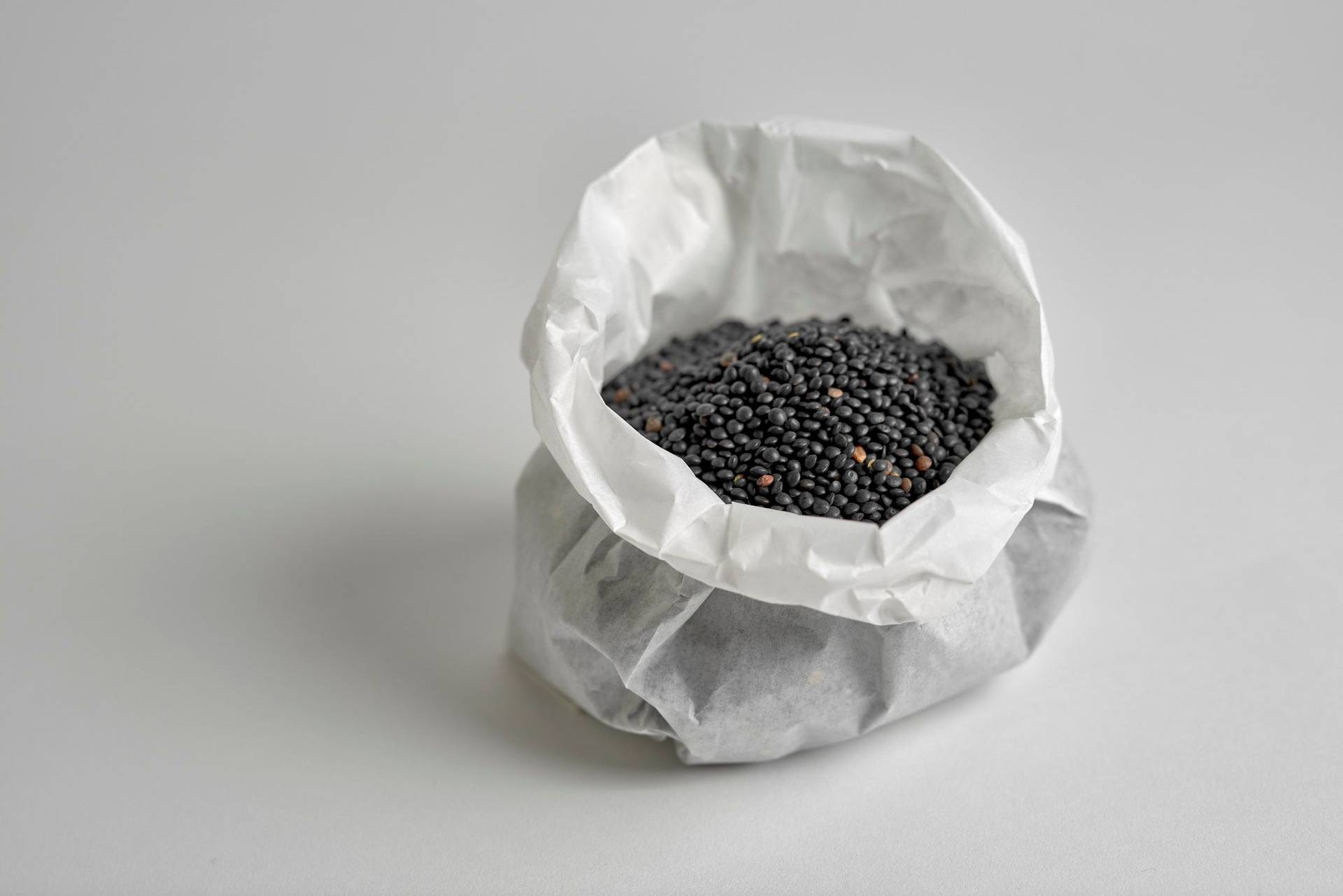 black-beluga-lentils black beluga lentils in a paper bag on white background