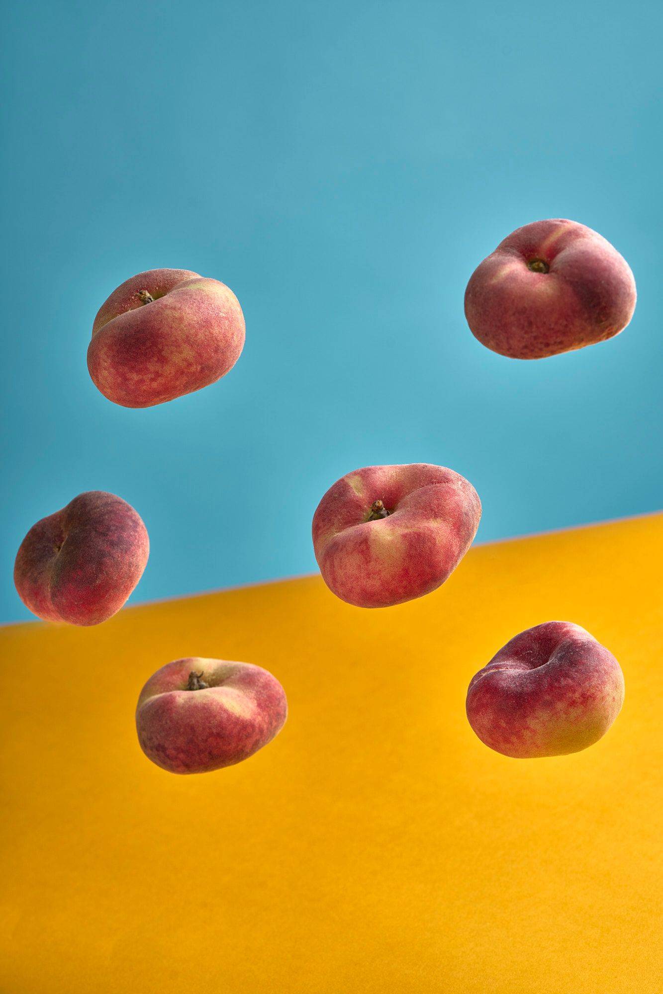 six white peaches with yellow and blue background
