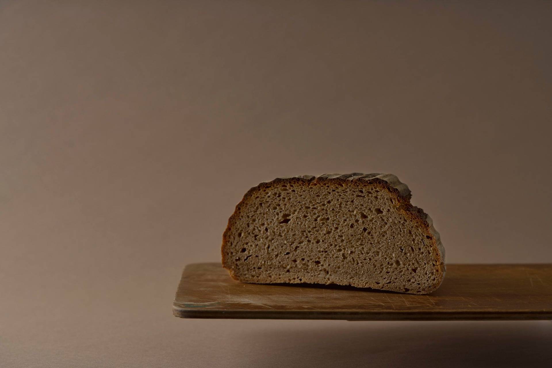 rye-sourdough-bread a loaf of rye sourdough bread on a wooden board with brown background